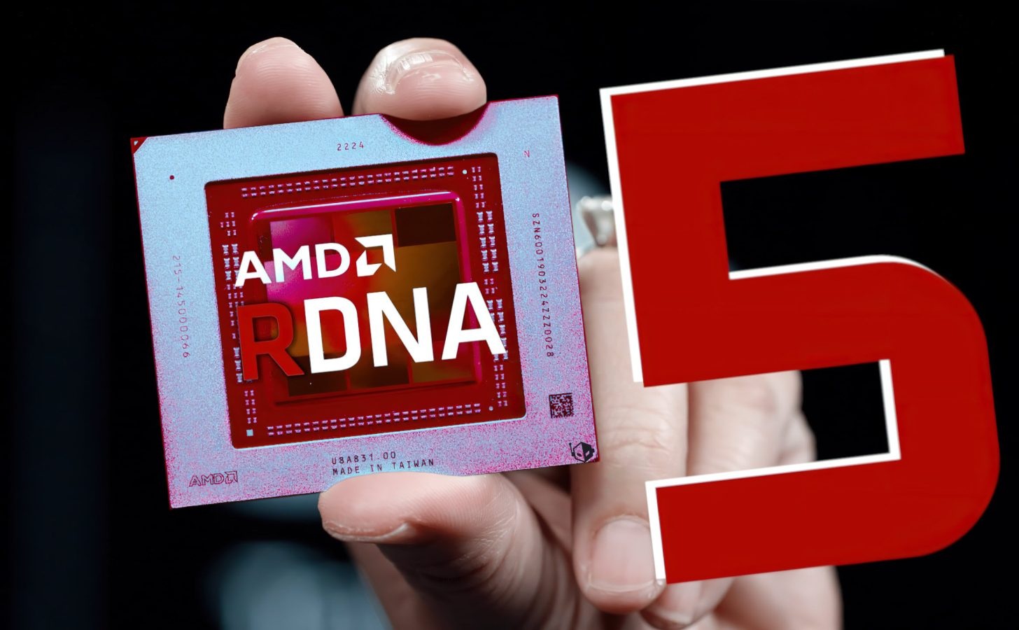 A close-up of an AMD RDNA chip being held next to a large red number 5.