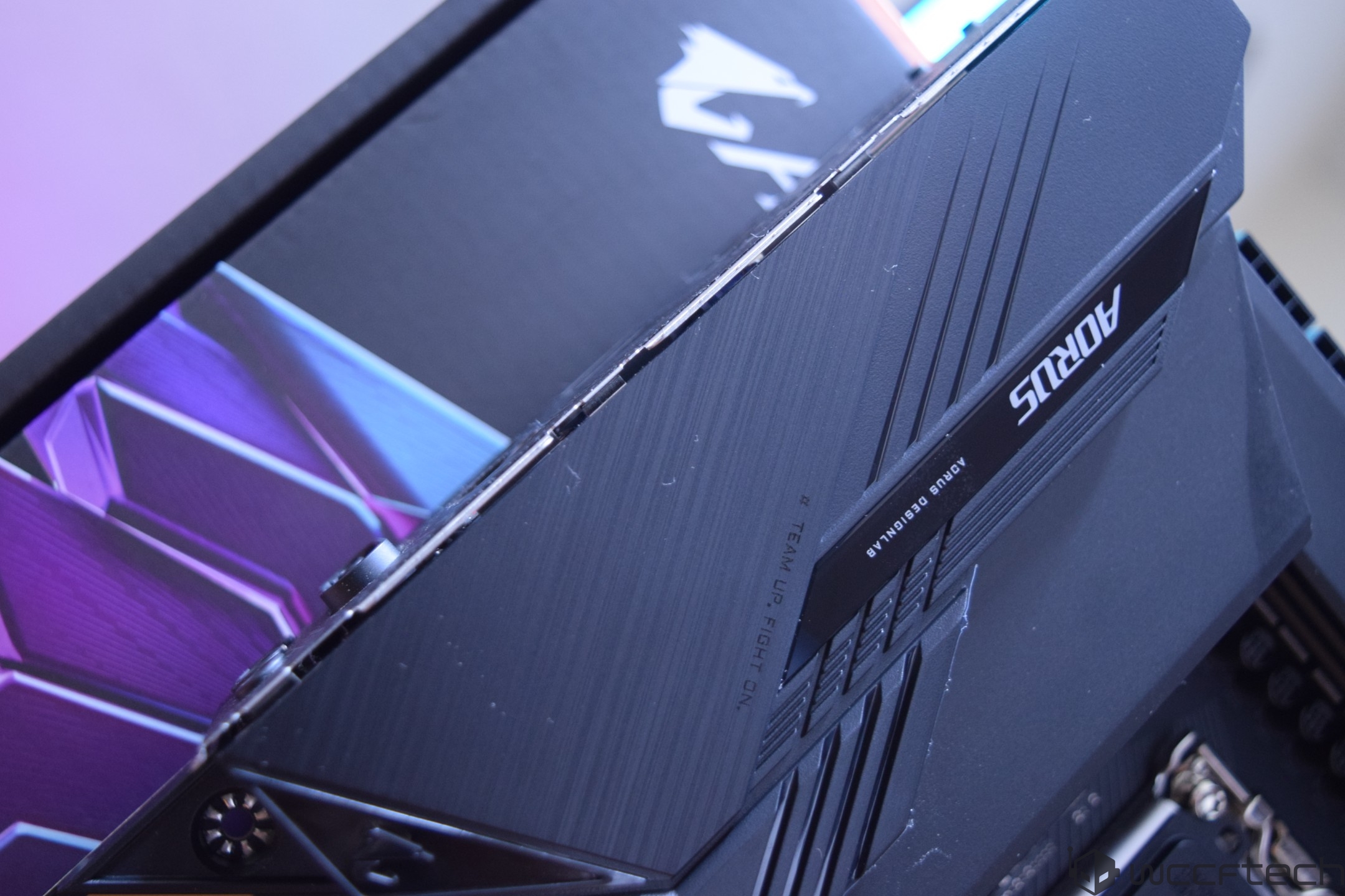 A close-up of an AORUS motherboard heatsink with the text '# TEAM UP. FIGHT ON.' displayed.