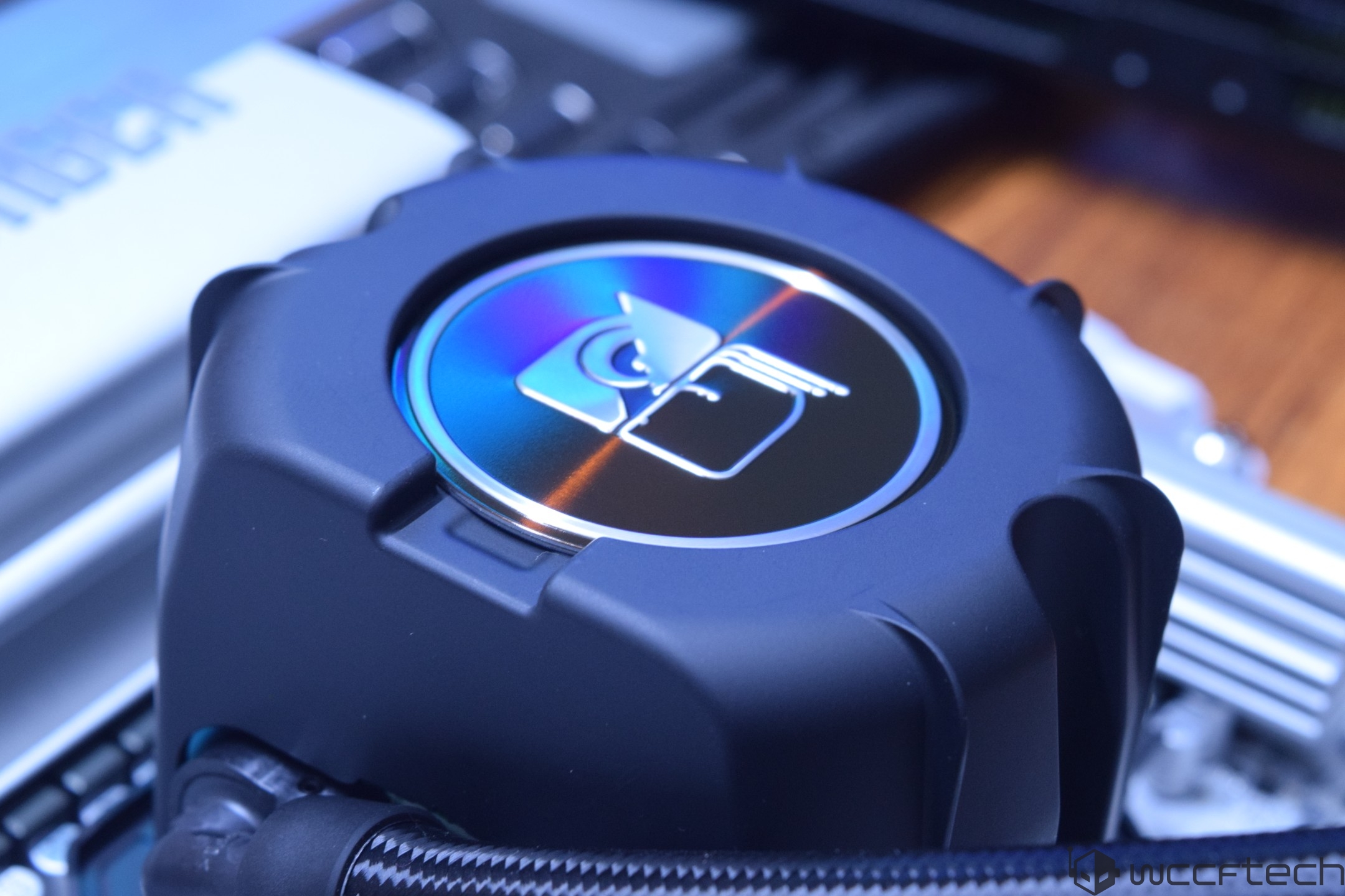 A close-up of a Fractal Design water cooling pump with a reflective logo on the top.