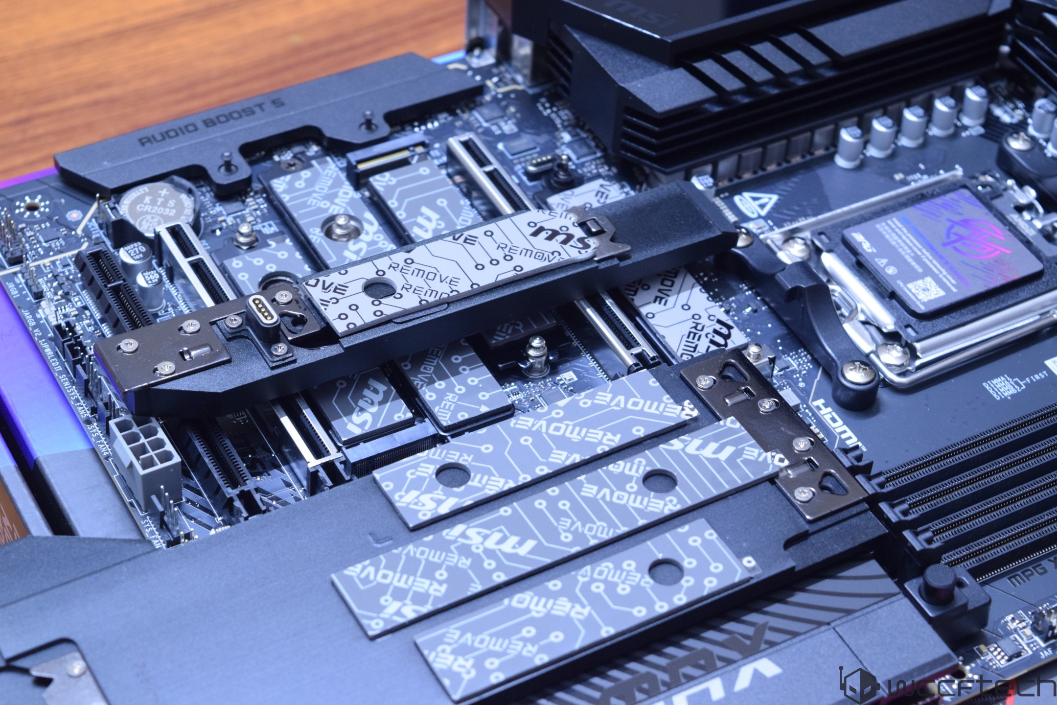 A close-up of an ASUS motherboard featuring an MSI Gen5 M.2 card and 'AUDIO BOOST 5' on the heatsink.