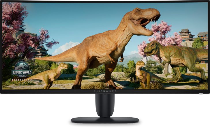 The Alienware monitor displays a scene from 'Jurassic World Evolution 2' featuring dinosaurs in a lush environment.