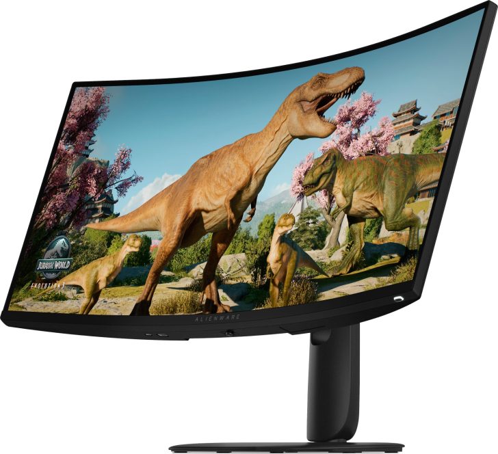 An Alienware curved monitor displaying a scene from 'Jurassic World Evolution 2' with dinosaurs in a forest setting.