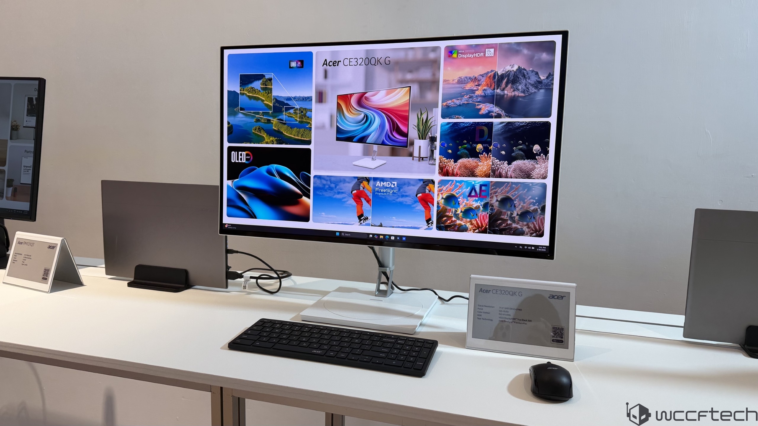 The image shows an Acer CE320QK G monitor displaying vibrant visuals with labels like 'OLED' and 'AMD FreeSync,' on a desk with a keyboard and mouse.