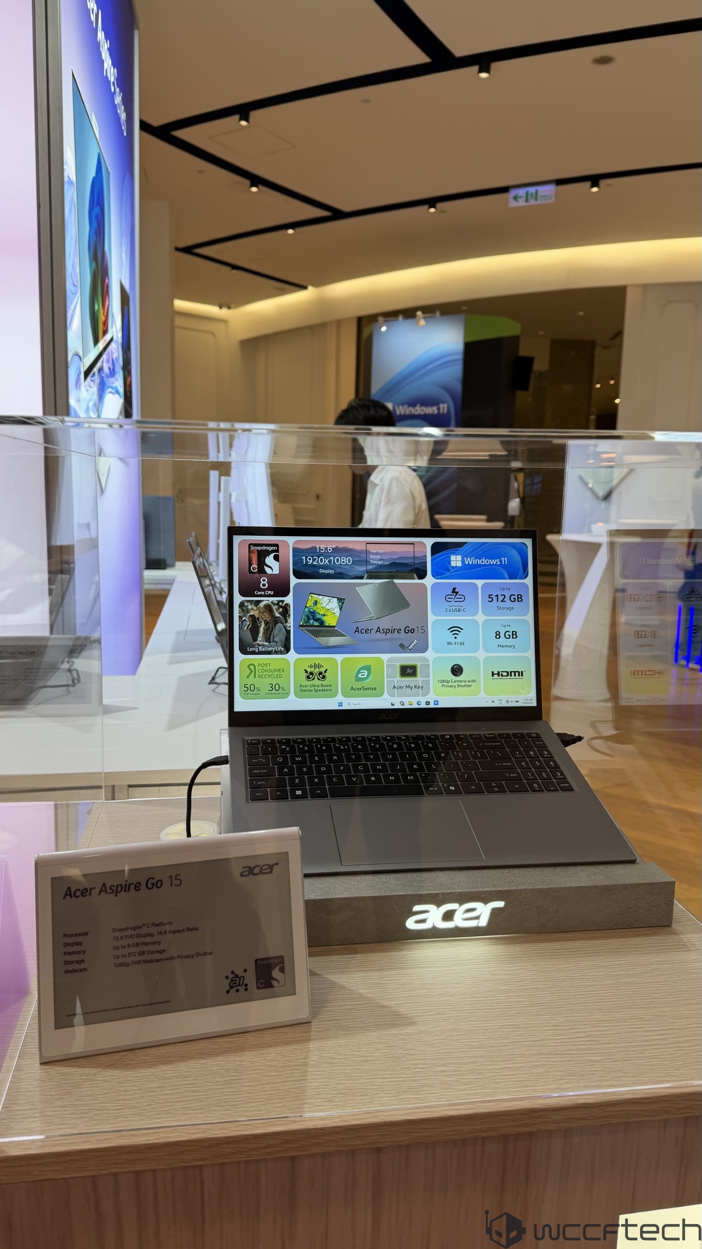 An Acer Aspire Go 15 laptop on display, showcasing its screen with specs including a Snapdragon 8 Core chip, a 15.6 1920x1080 FHD display, and features like 'Windows 11', 512 GB storage, and 8 GB memory.