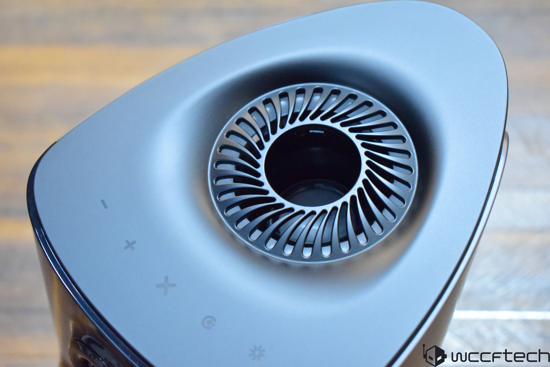A close-up of a sleek, black Intel-based desktop cooling device, featuring vent designs and touch controls with plus, minus, reset, and power icons.