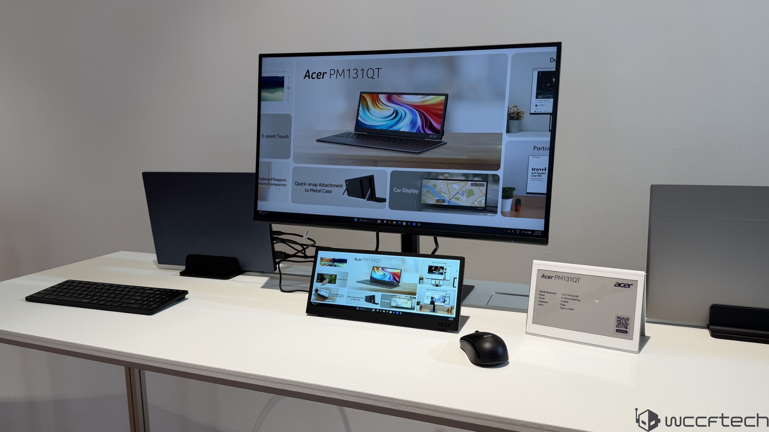 A display setup shows the Acer PM131QT portable monitor with its features highlighted on a connected screen and a spec card placed beside it.