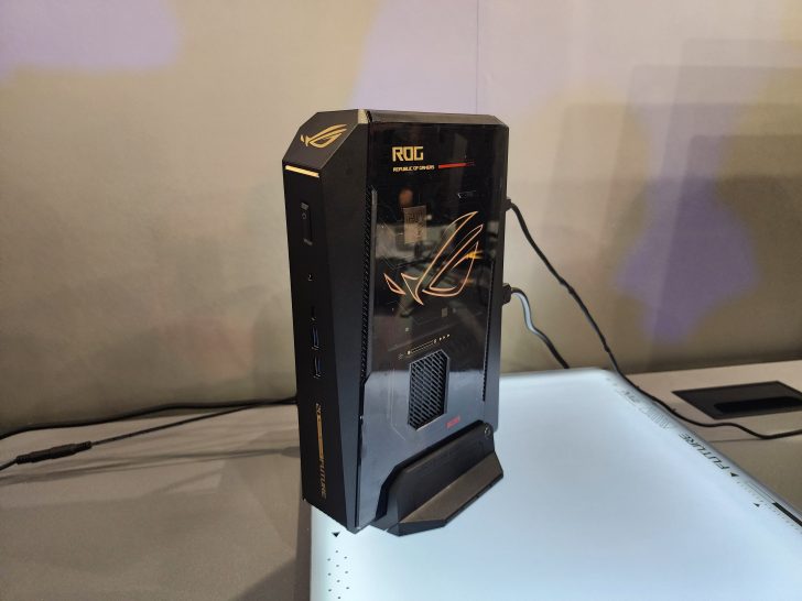 An ASUS ROG mini gaming desktop showcases the ROG logo and features multiple USB ports on its side.