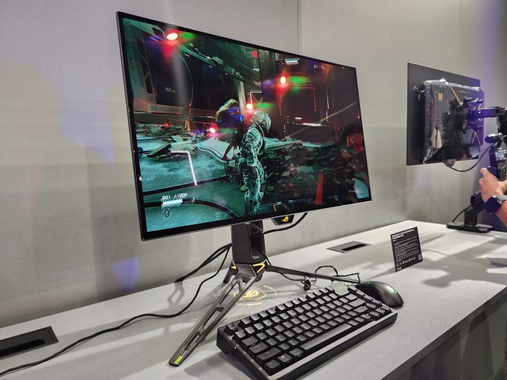 A gaming monitor displaying a scene from 'Doom' with a close-up of a character in a futuristic environment, connected to a ROG-branded setup.