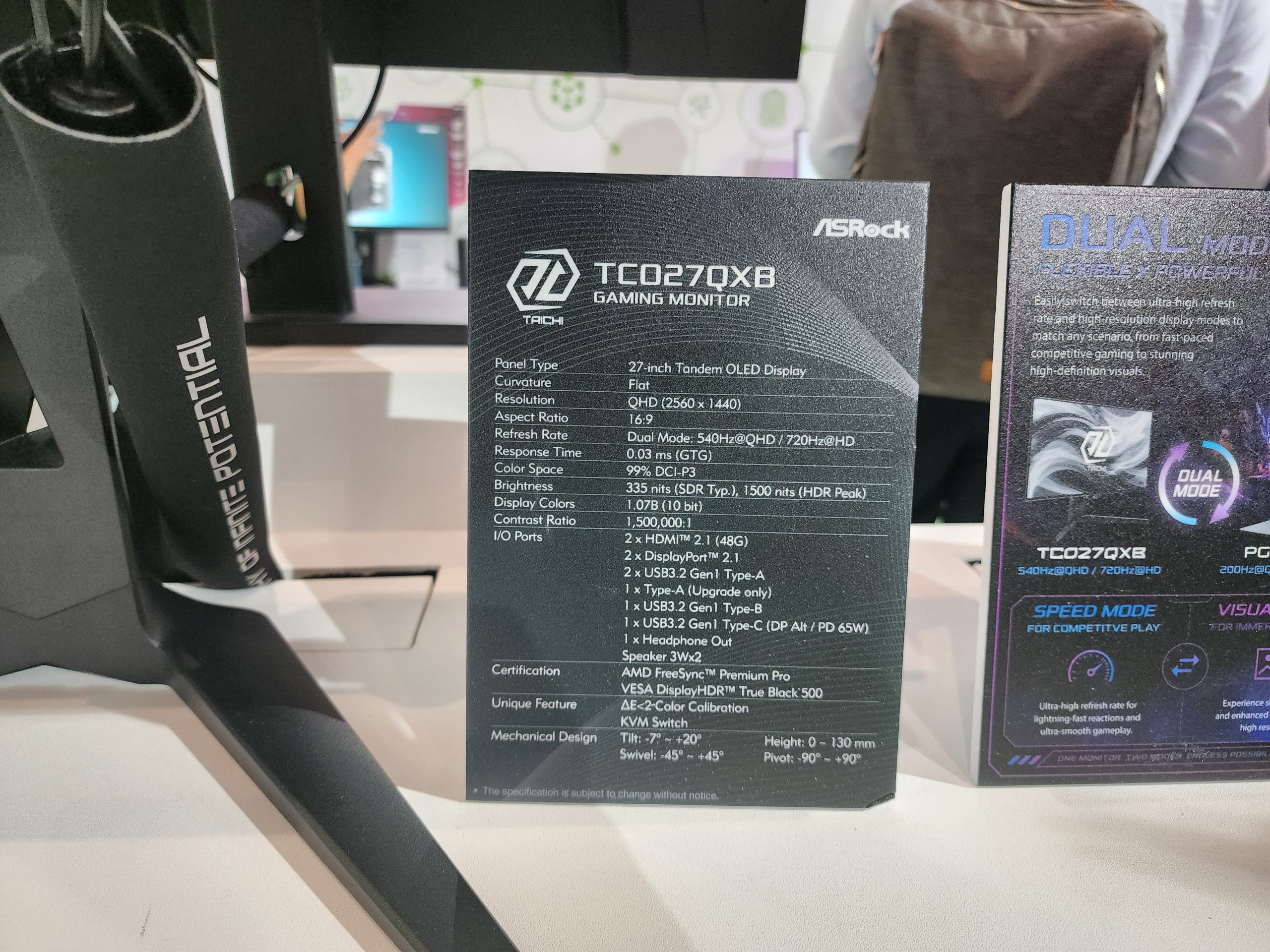 An ASRock display stand highlighting the specifications of the ASRock TCO27QX8 gaming monitor, featuring a 27-inch tandem OLED display with a resolution of 2560 x 1440 and a refresh rate of up to 240Hz.