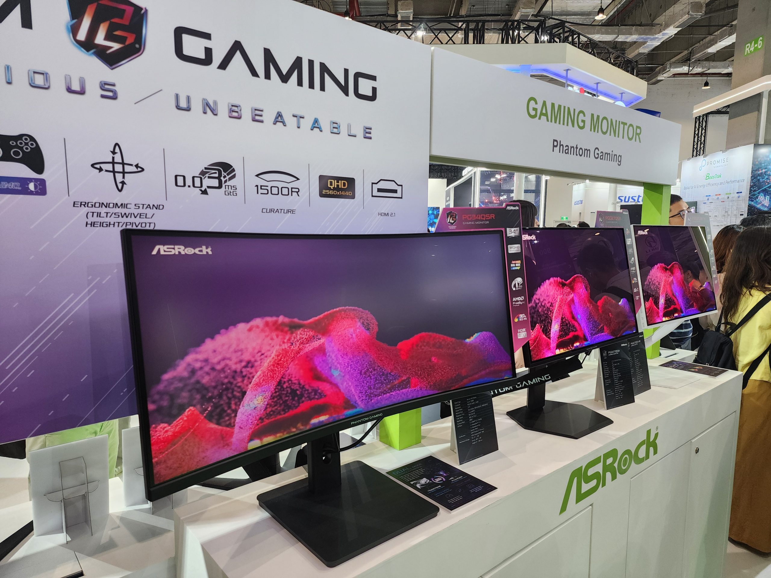 ASRock Phantom Gaming PG34QF screens are displayed demonstrating vivid imagery and gaming features like '0.1ms GTG' and 'QHD 2560x1440'.