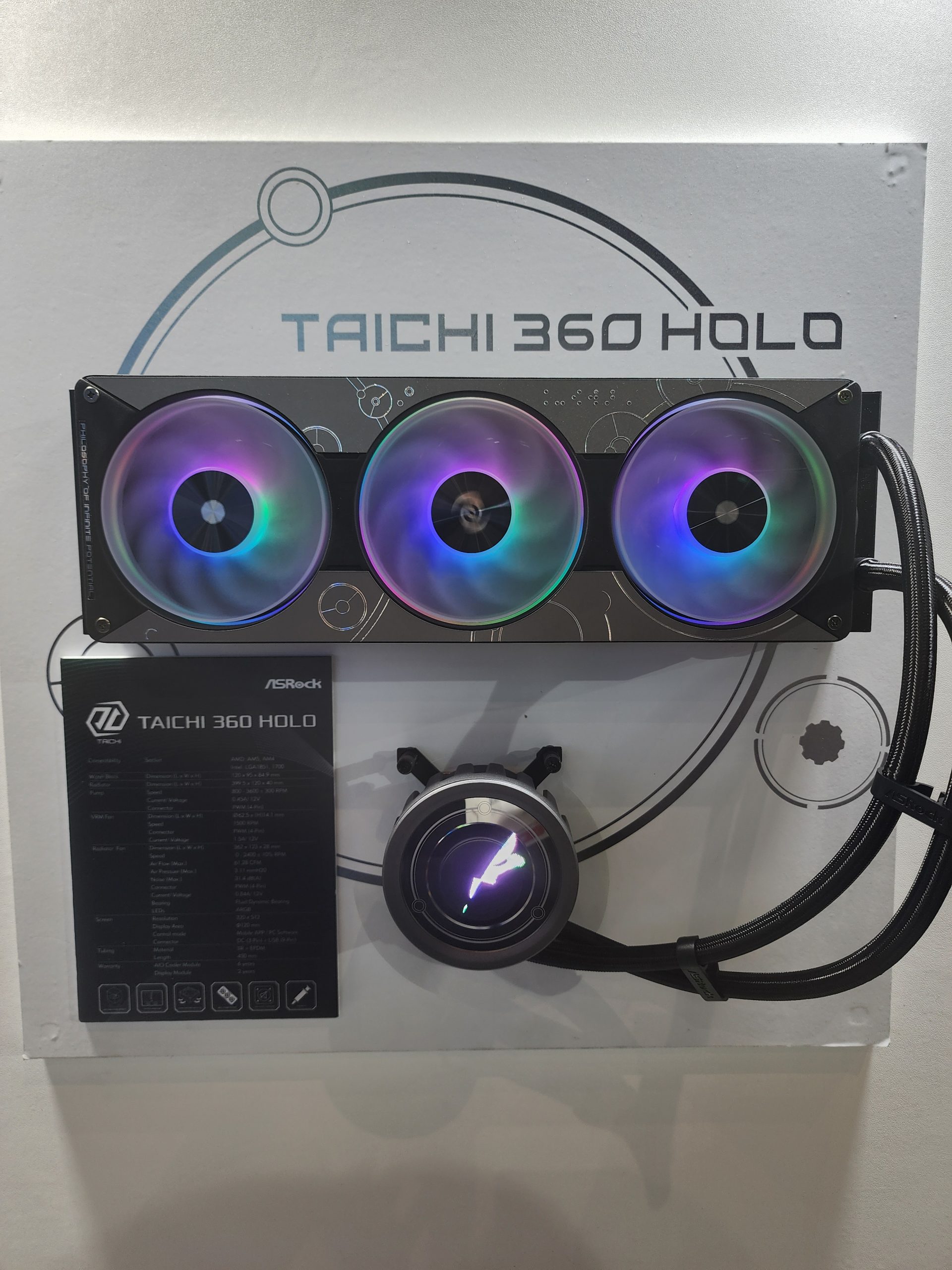 ASRock Taichi 360 Holo CPU cooler with RGB lighting displayed on a wall mount.
