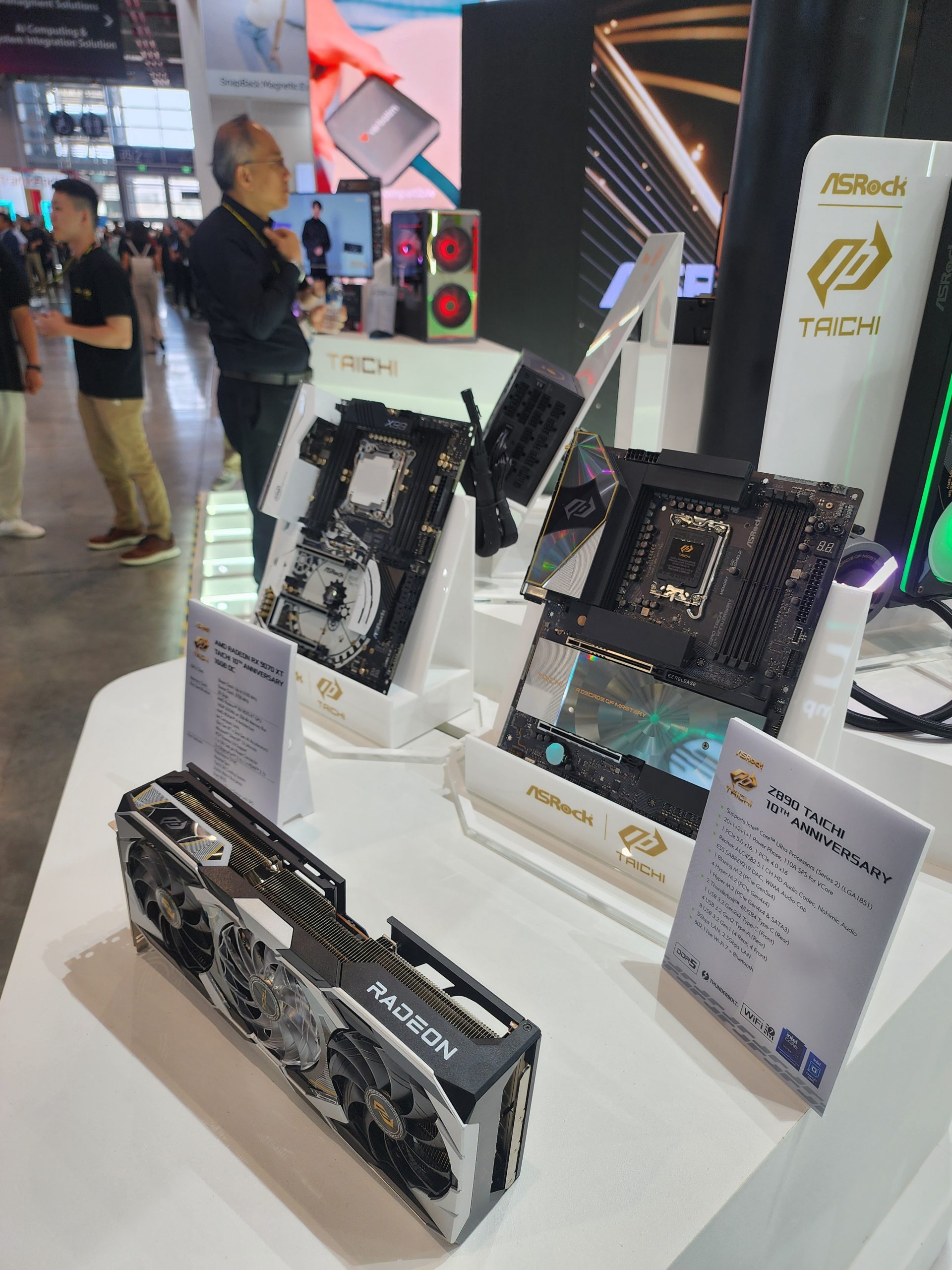 An ASRock 'Z790 Taichi 10th Anniversary' motherboard is displayed alongside a custom ASRock Radeon graphics card at a tech showcase.