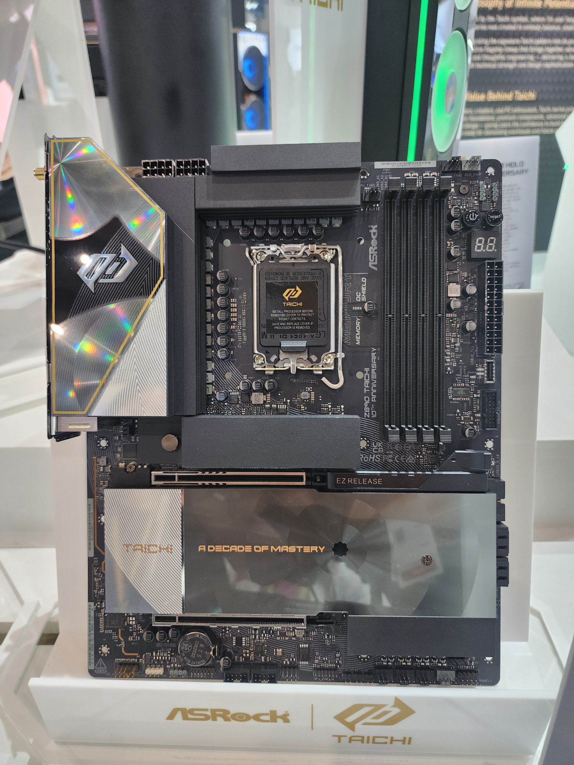 An ASRock Z790 Taichi Lite motherboard is displayed with 'A Decade of Mastery' written on its cover, alongside dual PCIe slots and four RAM slots.