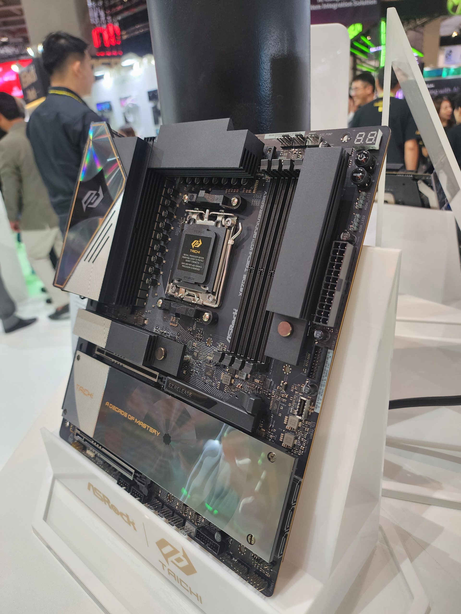 An ASRock Taichi motherboard on display, featuring a 'Z790 Taichi' inscription and 'A Decade of Mastery' text on the heatsink.