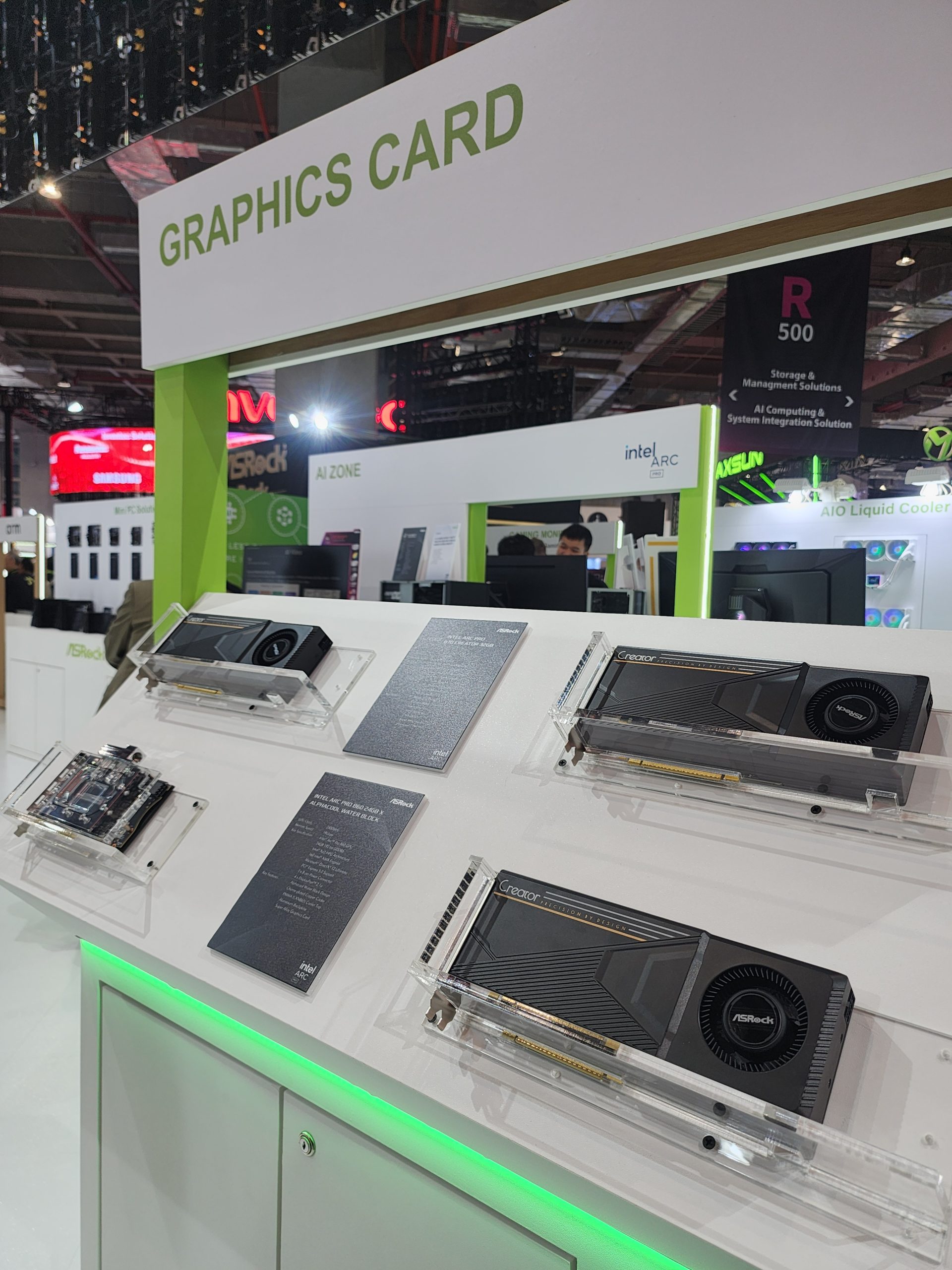 A display of ASRock graphics cards, including models from the Creator series, under a sign reading 'Graphics Card' at a tech expo.