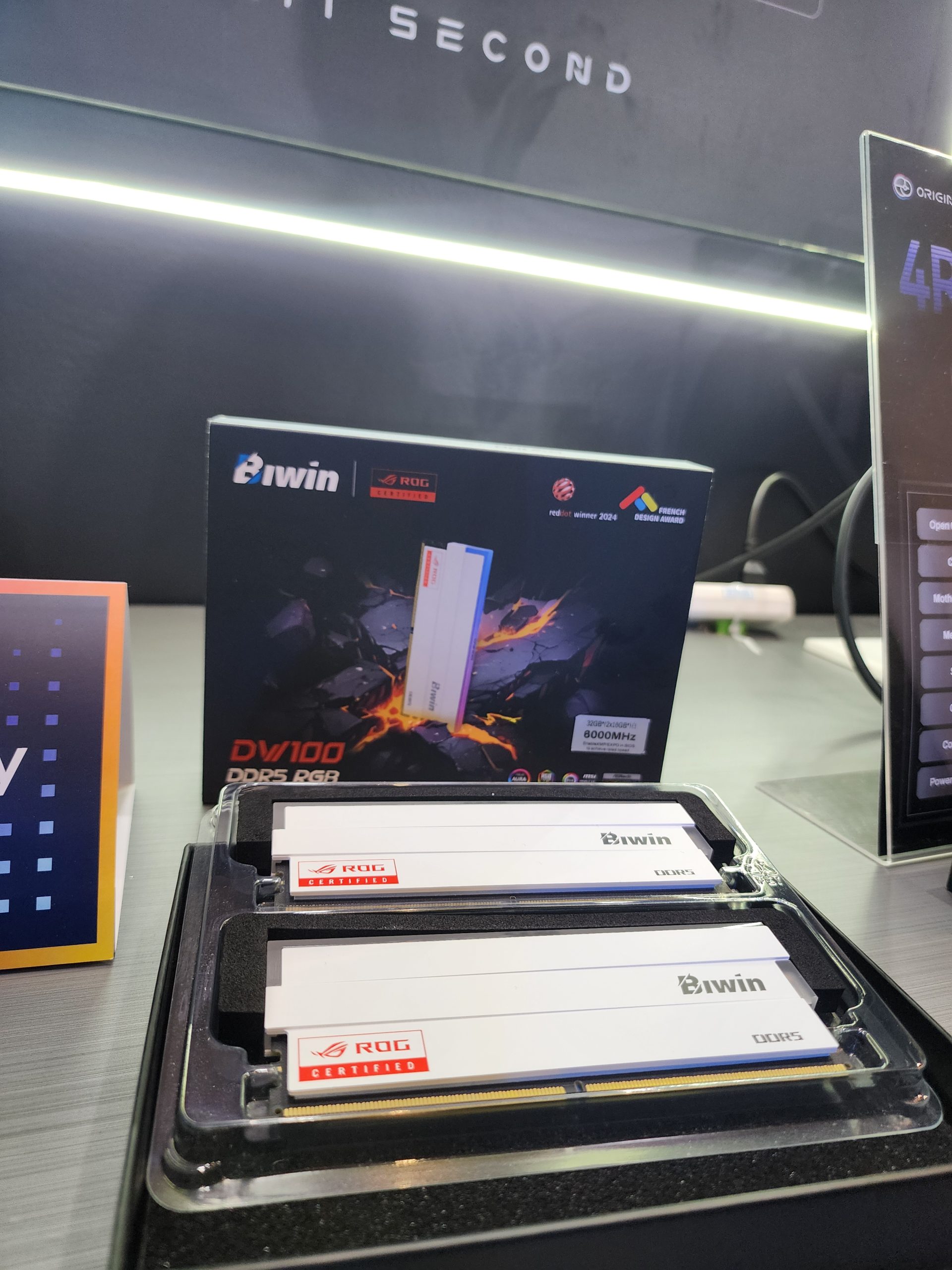 Biwin DDR5 RGB memory modules displayed with packaging labeled 'DV100 DDR5 RGB' and a sticker showing '8000MHz', marked as ROG Certified.