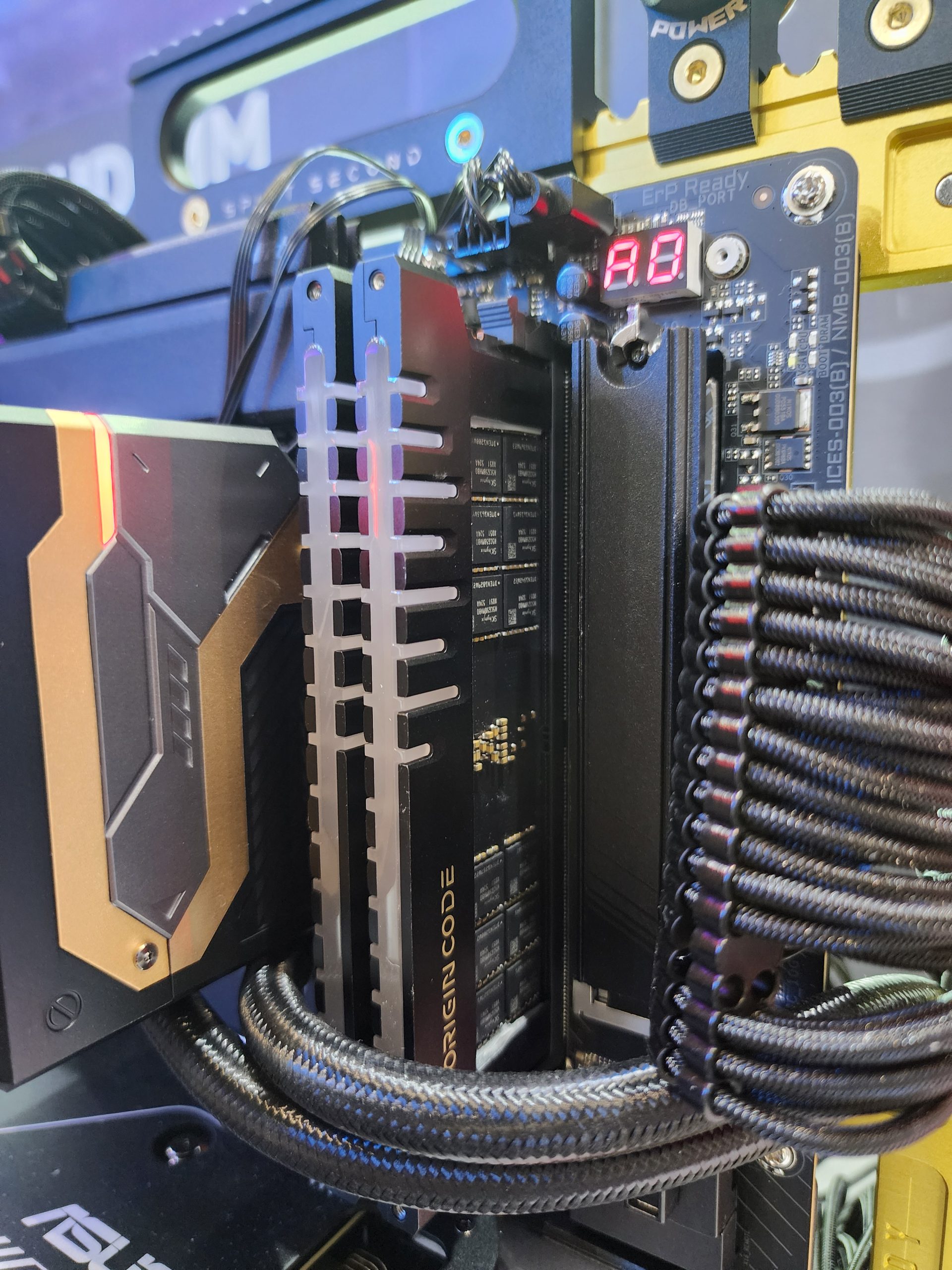 A close-up of an ORIGIN CODE memory module installed on a motherboard displaying a debug LED code 'A0'.