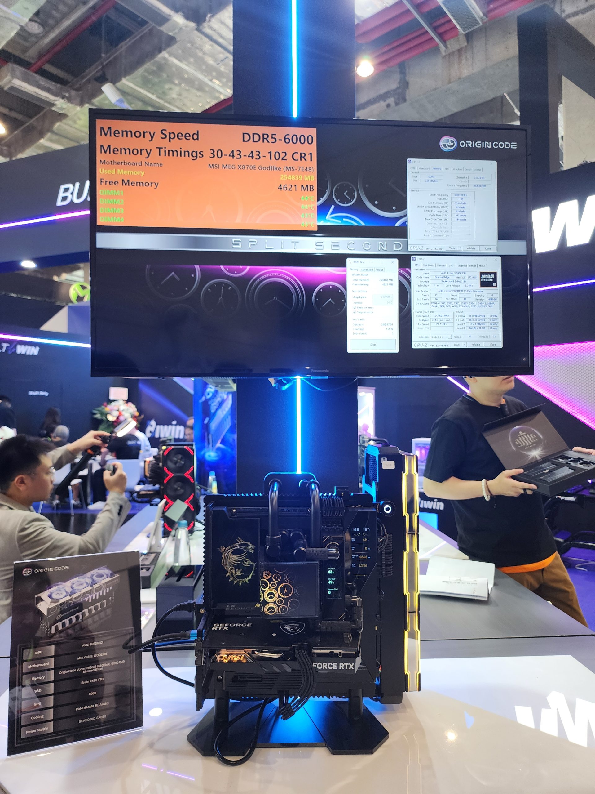A display shows the MSI MEG X670E Godlike motherboard with a memory speed of 'DDR5-6000' and memory timings '30-43-43-102 CR1' at a tech exhibit, alongside a visible setup featuring an NVIDIA GeForce RTX graphics card.