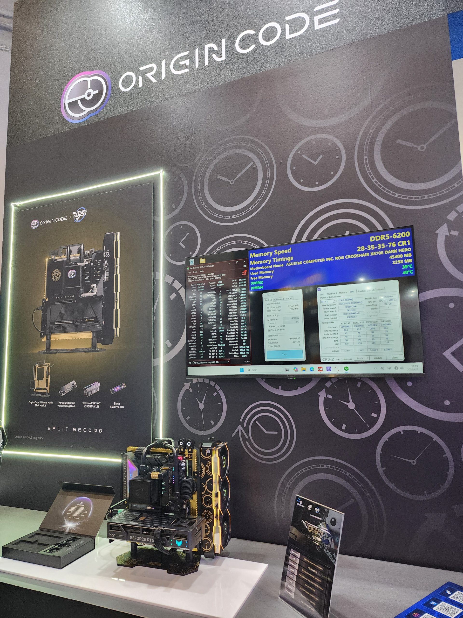 A display booth featuring Origin Code branding showcases a setup with an open PC build, a GeForce RTX graphics card, and a screen displaying memory details including 'DDR5-6200' on an ASUS ROG Crosshair X670E Dark Hero motherboard.