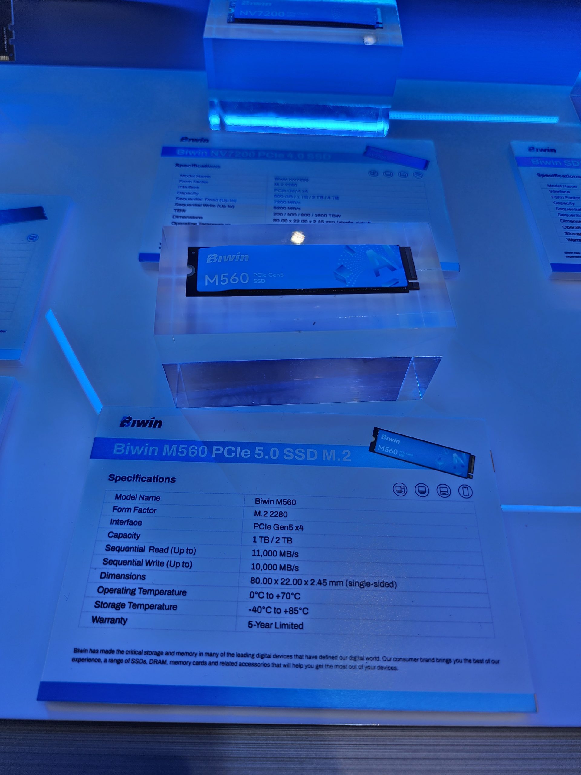The image shows a Biwin M560 PCIe Gen5 SSD M.2 with specifications listing capacities of 1 TB and 2 TB, sequential read speeds up to 11,000 MB/s, and sequential write speeds up to 10,000 MB/s.