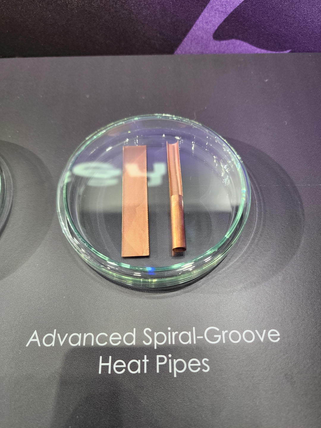 Two copper heat pipes are displayed on a clear dish with the text 'Advanced Spiral-Groove Heat Pipes' below them.