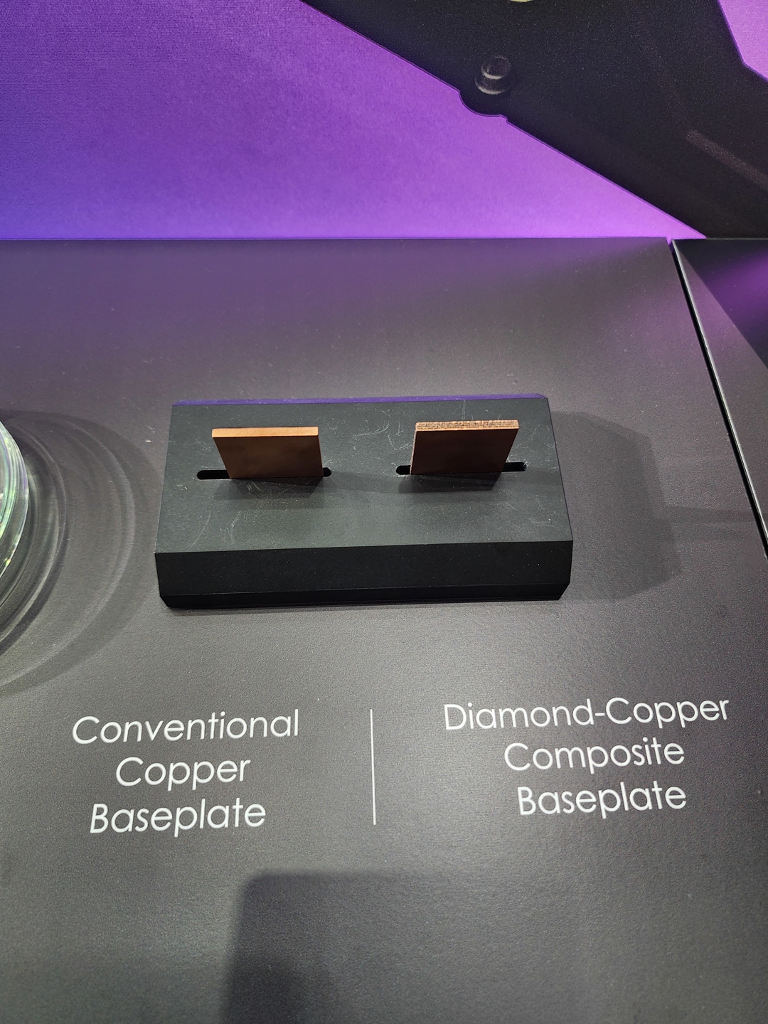 Two baseplate samples labeled 'Conventional Copper Baseplate' and 'Diamond-Copper Composite Baseplate' are displayed on a black platform.