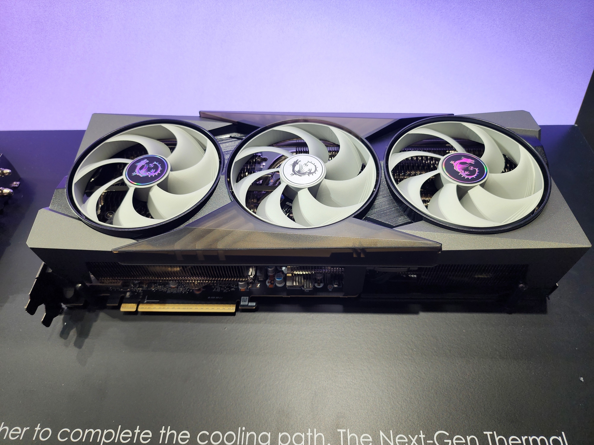 An MSI graphics card with three cooling fans on display against a purple background.