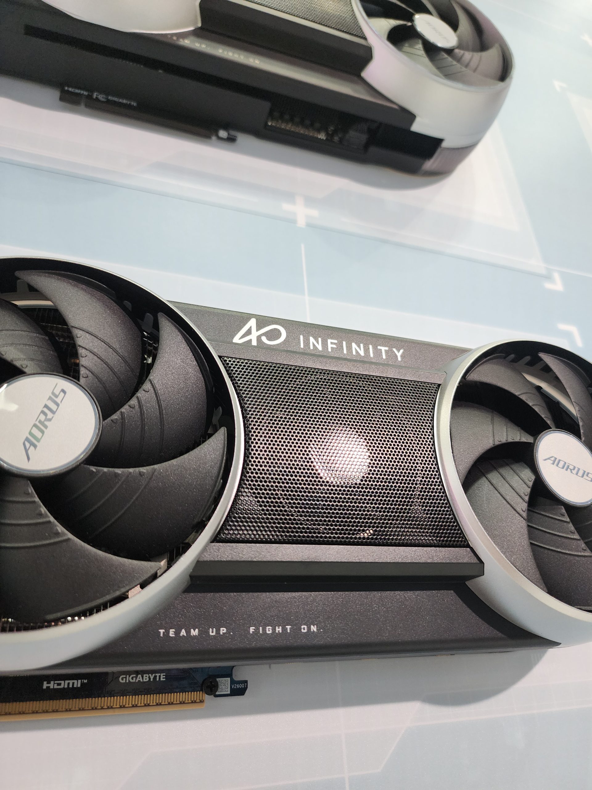 A GIGABYTE AORUS graphics card with INFINITY branding and text 'TEAM UP. FIGHT ON.' displayed prominently.