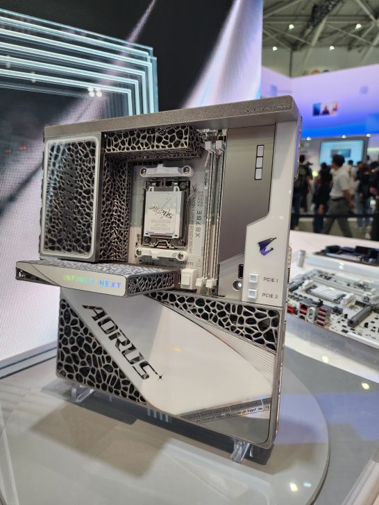 A close-up of a Gigabyte Aorus X9 BTD5E motherboard with a prominent 'Infinity Next' label and intricate design details displayed at a technology exhibition.