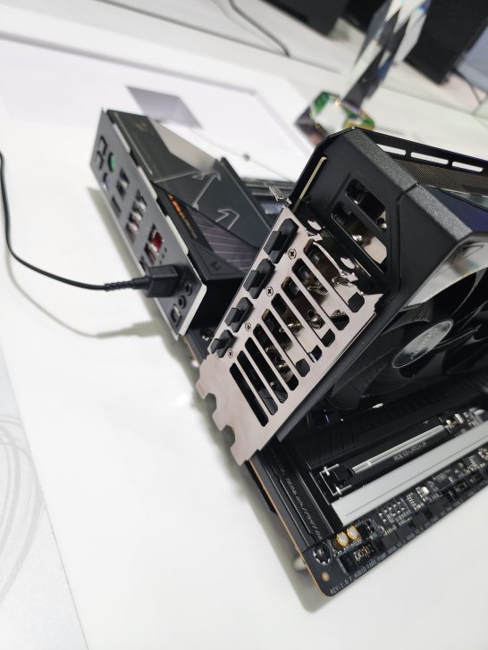 A graphics card installed on a motherboard connected to a series of ports, with visible branding on the card and motherboard.