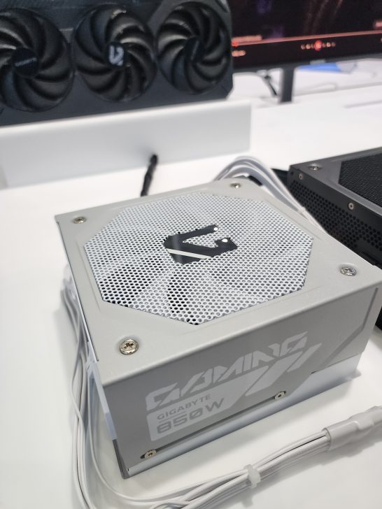 A close-up of a Gigabyte Gaming 850W power supply with a visible cooling fan in the background.