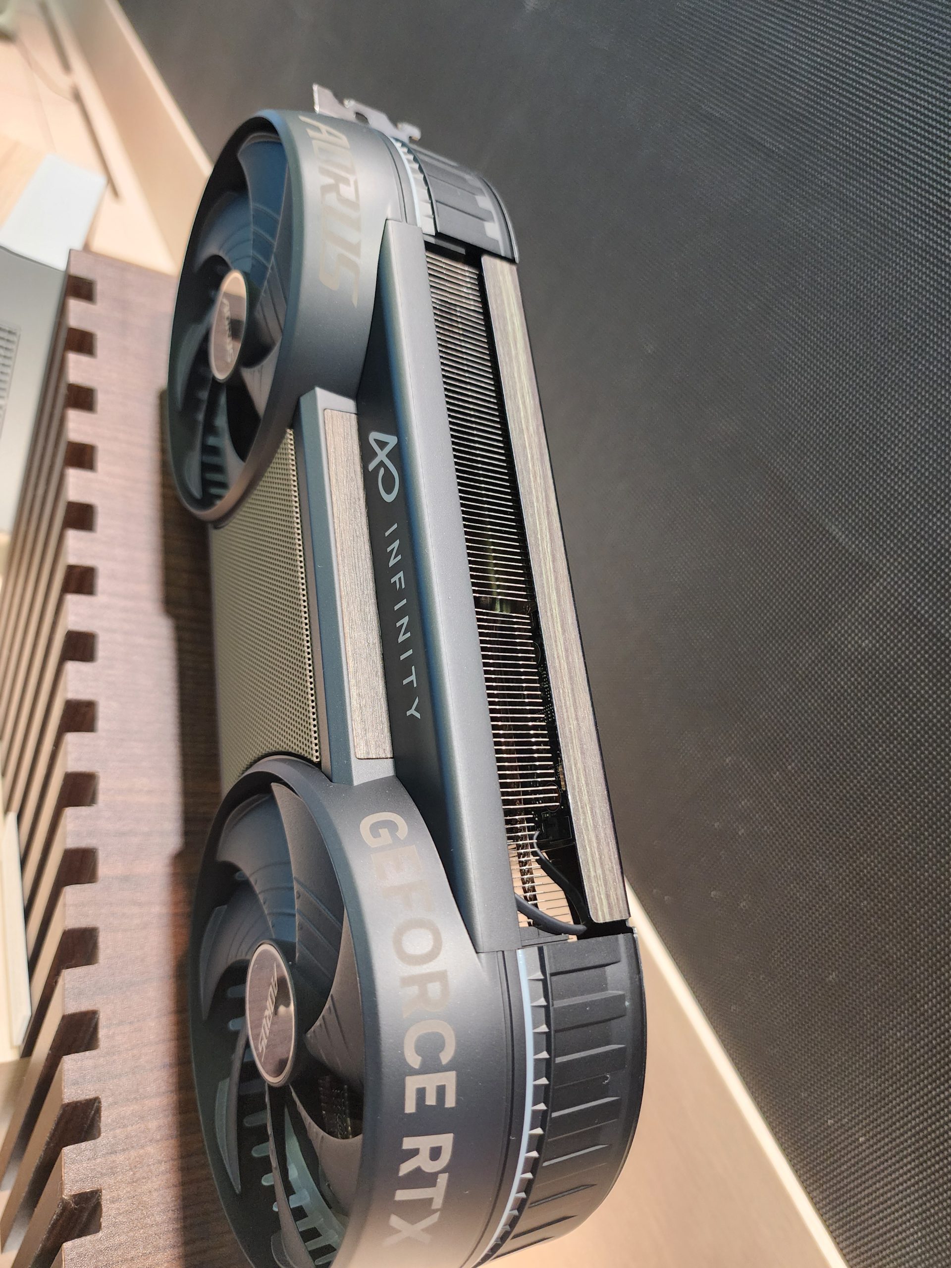 A close-up of a Gigabyte AORUS GeForce RTX graphics card with the word 'INFINITY' on the side and large cooling fans.