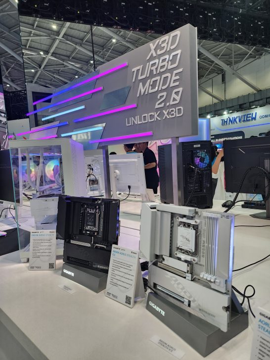Gigabyte motherboards labeled B650M AORUS STEALTH and B650M AORUS STEALTH ICE are displayed under a sign that reads 'X3D Turbo Mode 2.0 Unlock X3D'.