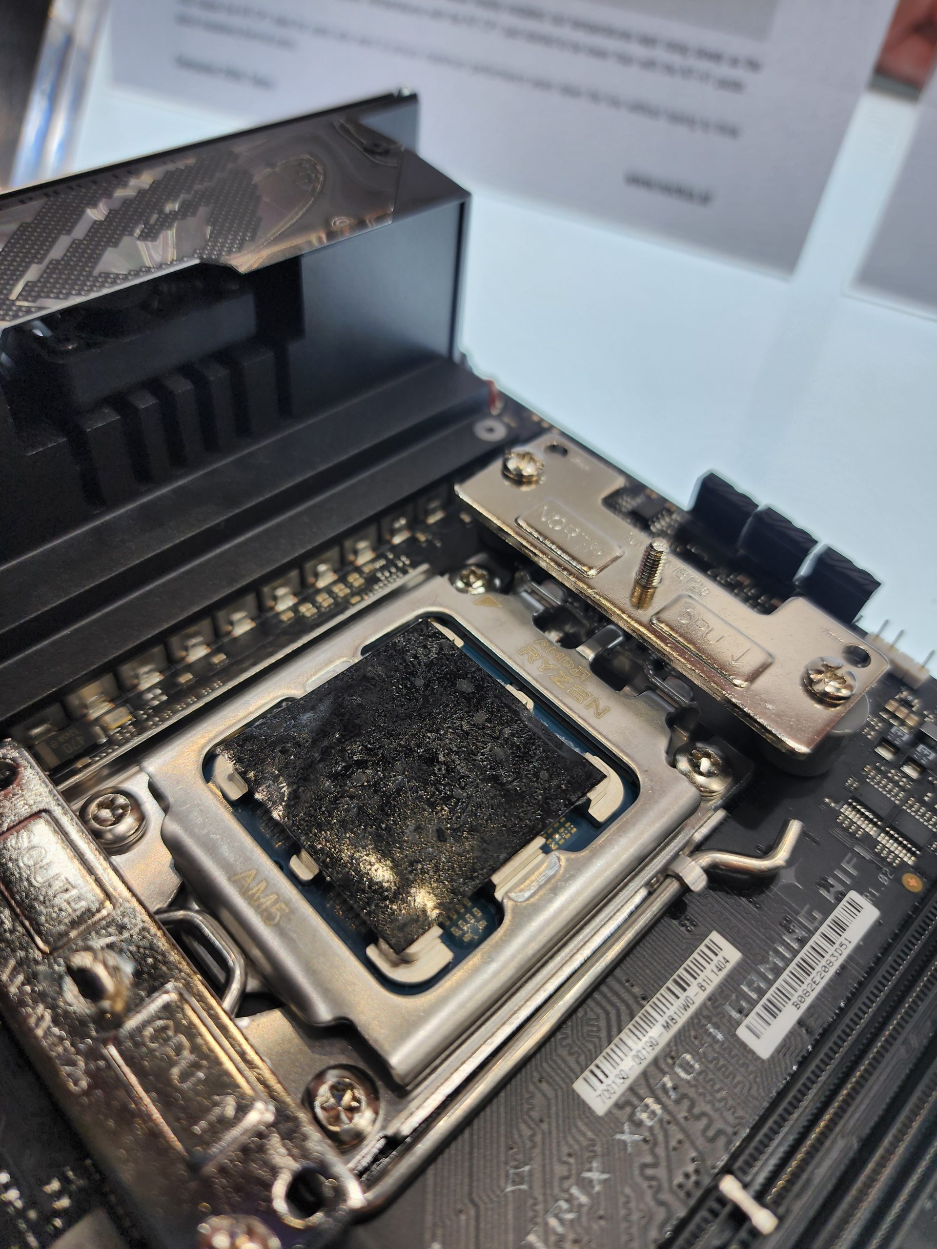 A damaged AMD Ryzen processor in an AM5 socket inside a motherboard.