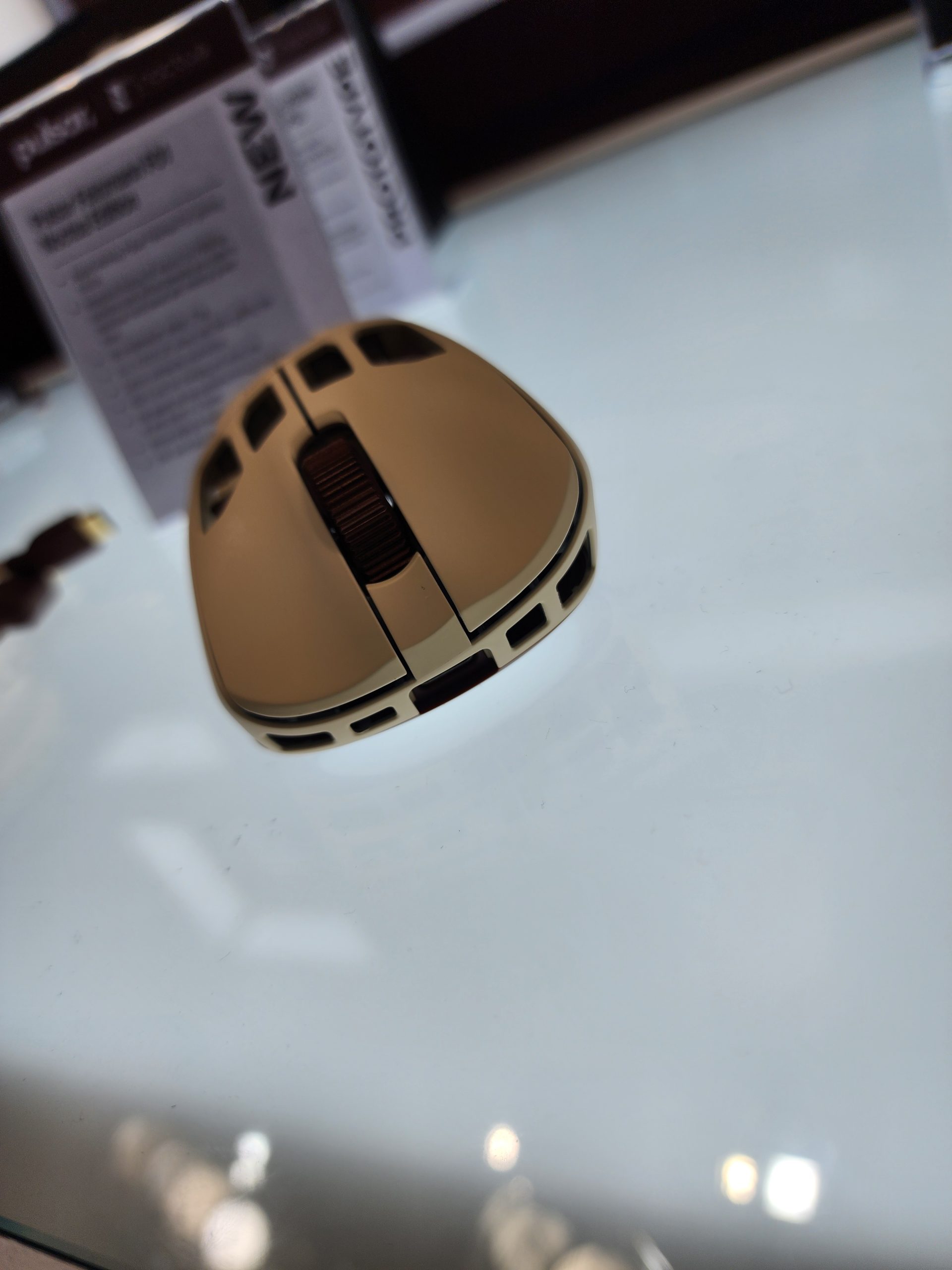 A Glorious Model D wireless gaming mouse on display next to its packaging.