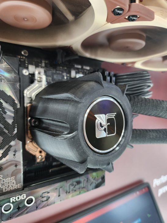A close-up of an ASUS ROG Strix motherboard with a custom water cooling setup installed.