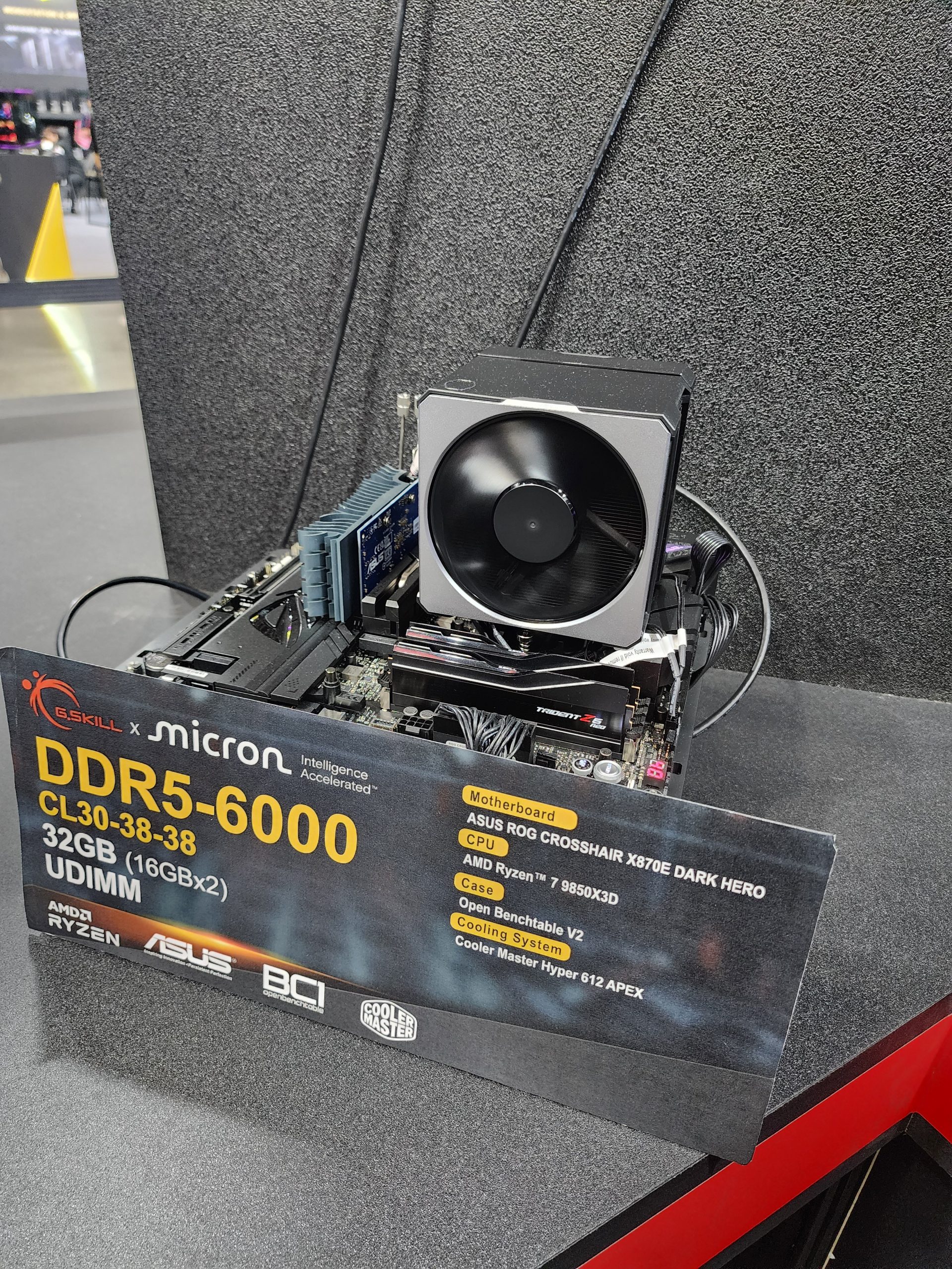 A test setup featuring G.Skill x Micron DDR5-6000 UDIMM CL30-38-38 32GB (16GBx2) RAM on an ASUS ROG Crosshair X670E Dark Hero motherboard with an AMD Ryzen 7 9850X3D CPU and a Cooler Master Hyper 612 APEX cooling system.
