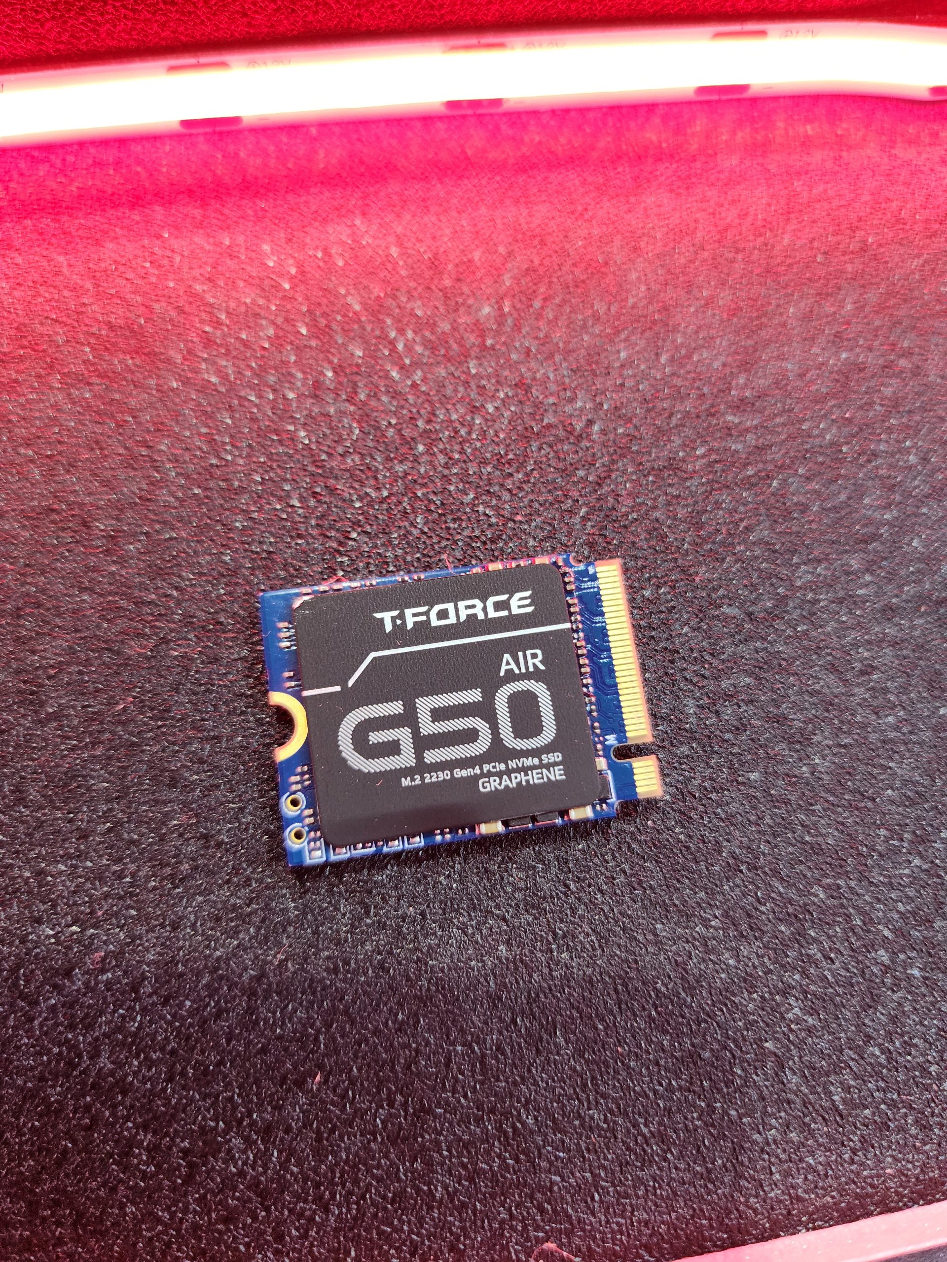 The image shows a T-Force G50 Air M.2 2230 Gen4 PCIe NVMe SSD with 'GRAPHENE' branding placed on a textured surface.