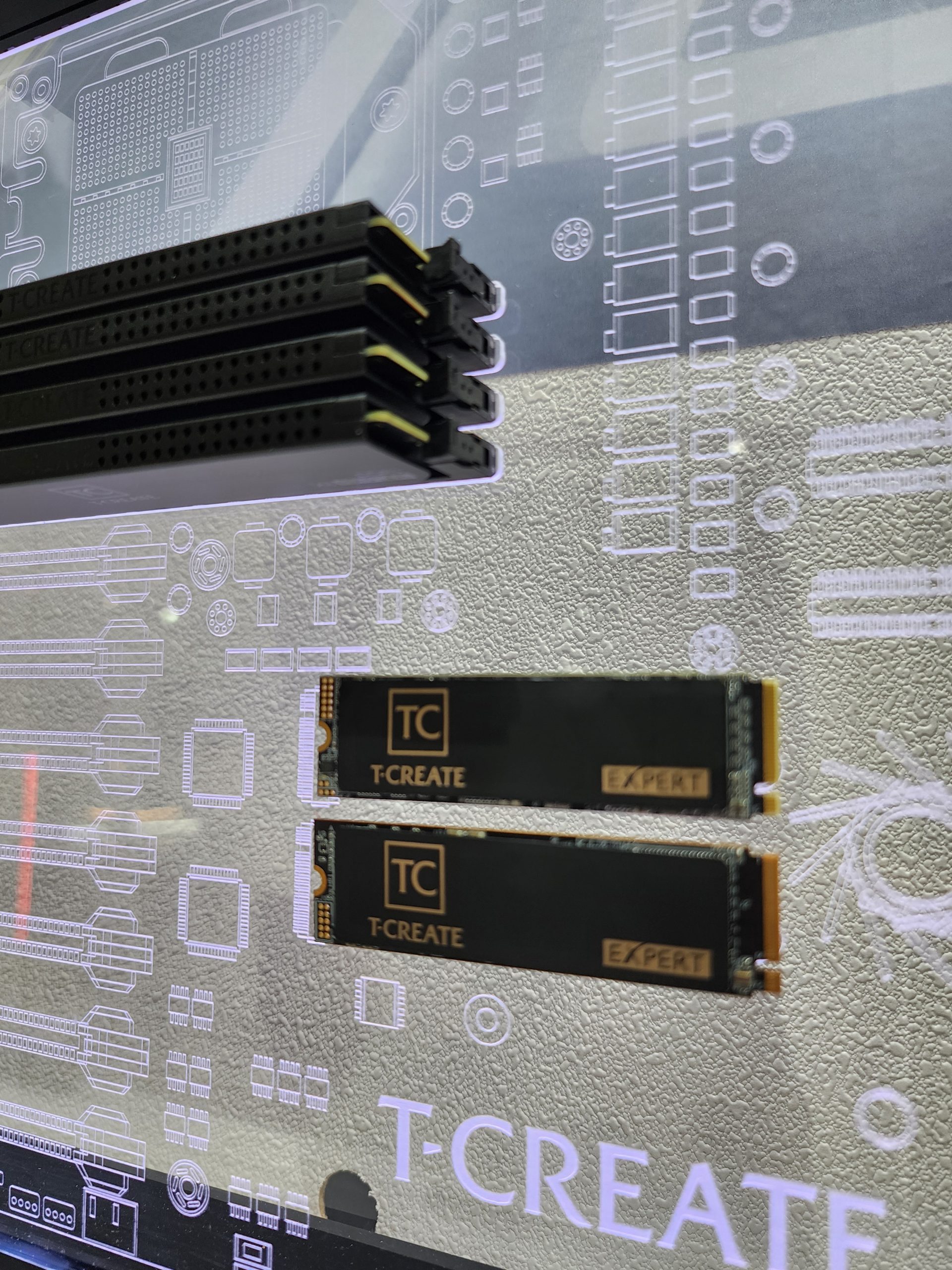 T-CREATE Expert SSDs and RAM modules are displayed against a circuit design background.