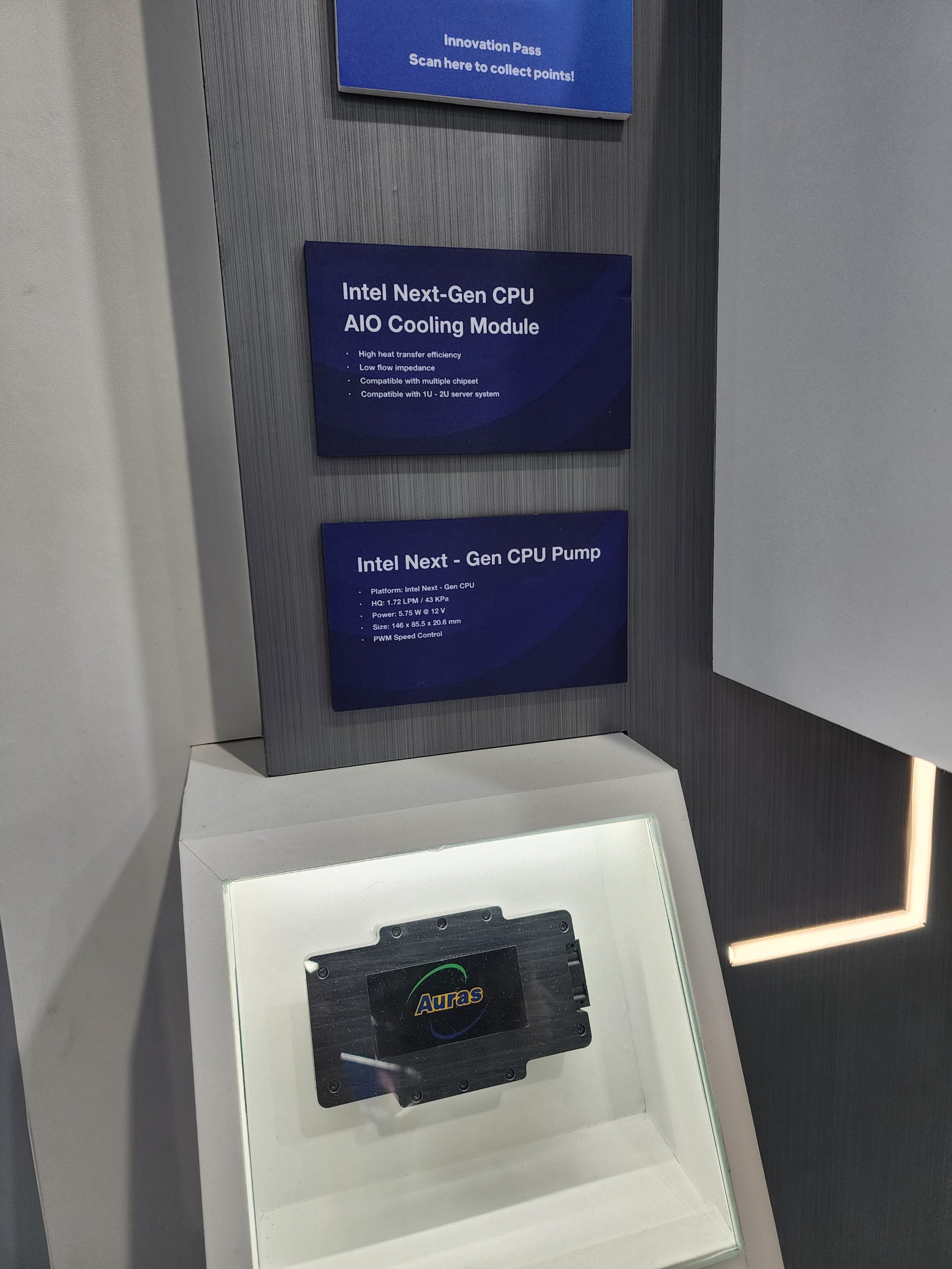 A display showcases an Intel Next-Gen CPU AIO Cooling Module above an Auras-branded component.