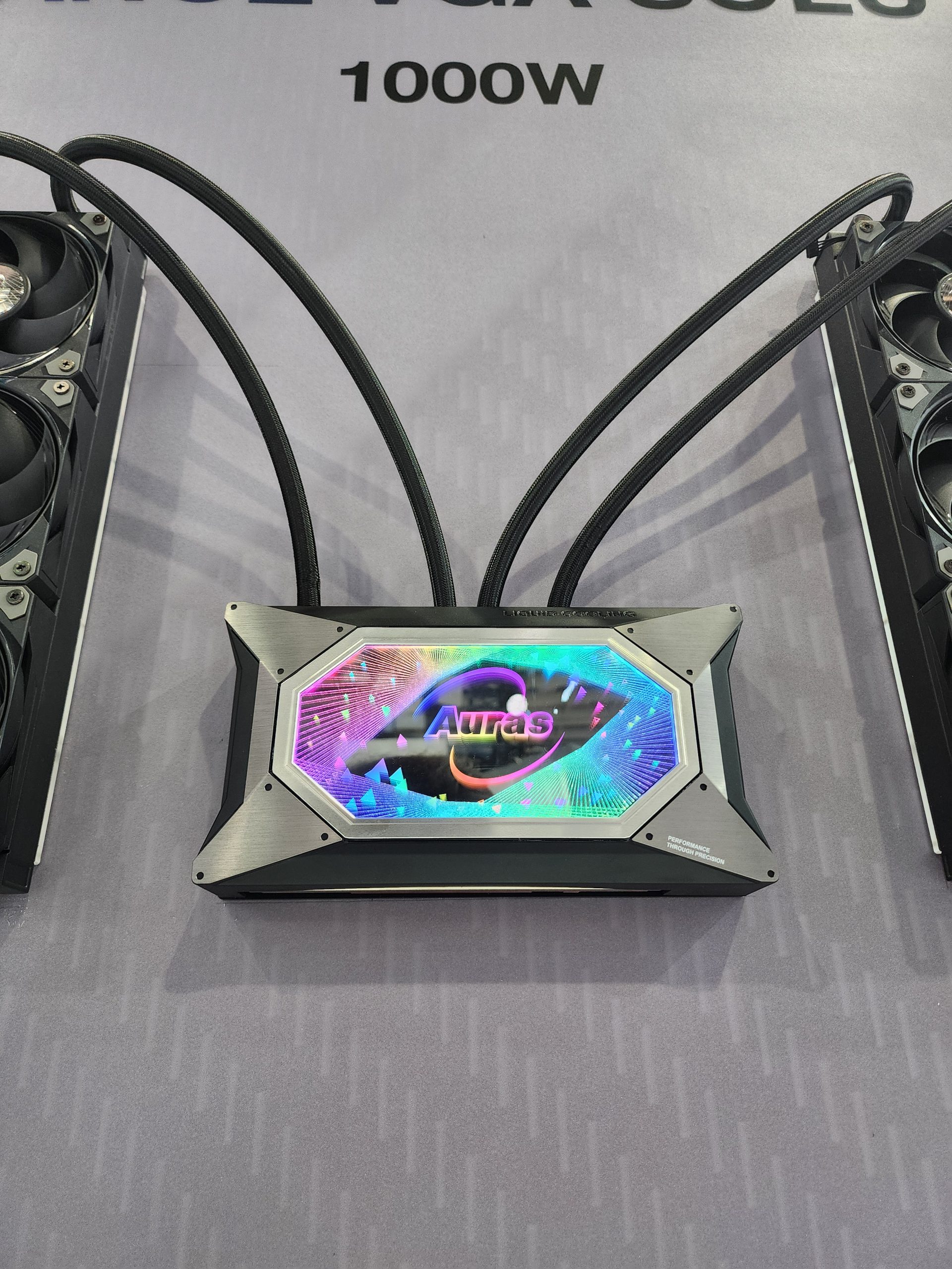 An Auras RGB liquid cooling unit with multiple hoses is displayed, labeled '1000W.'