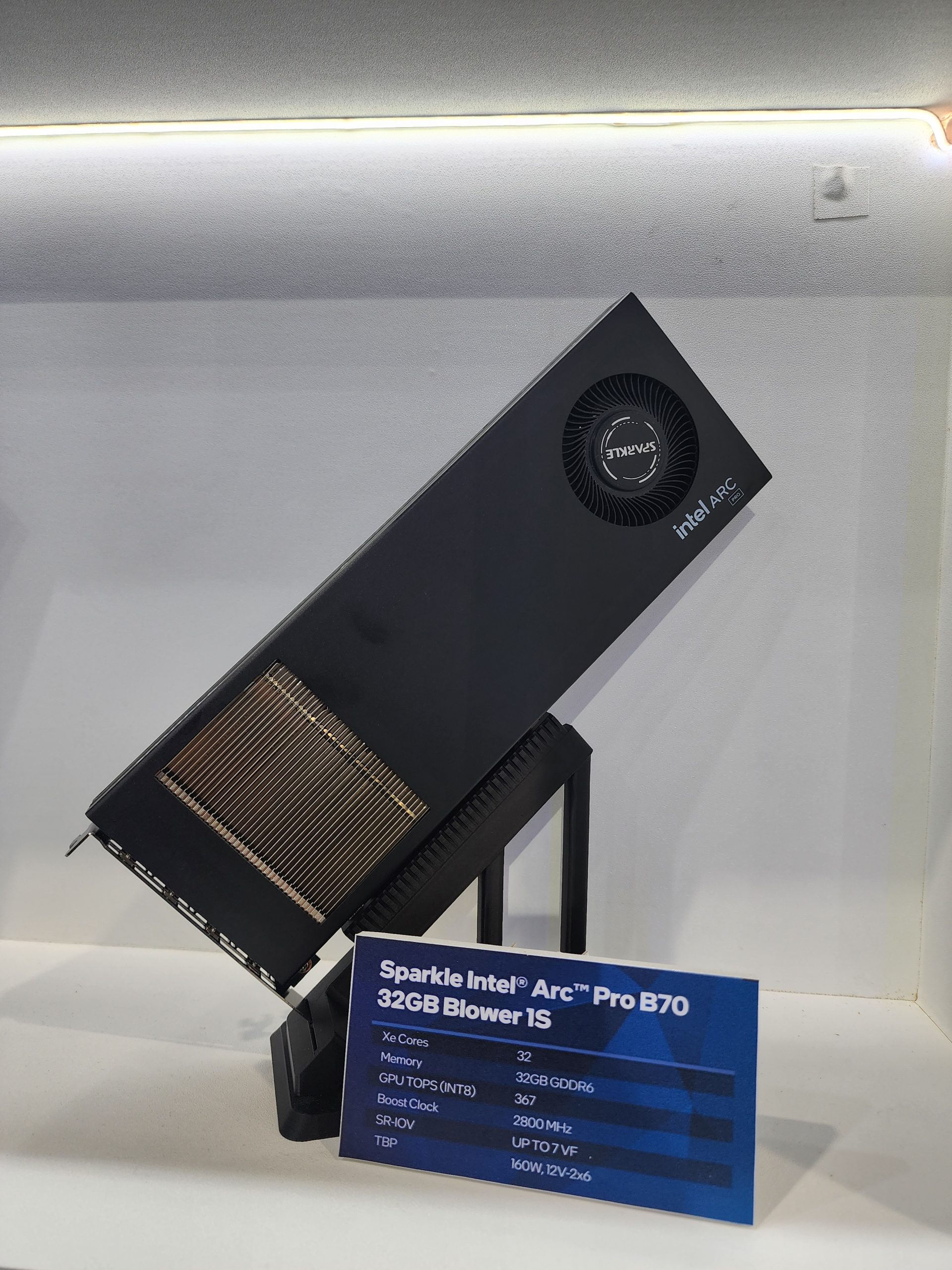 The Sparkle Intel Arc Pro B70 graphics card is displayed with a specification card listing details such as '32GB Blower 1S' and a boost clock of '2800 MHz.'