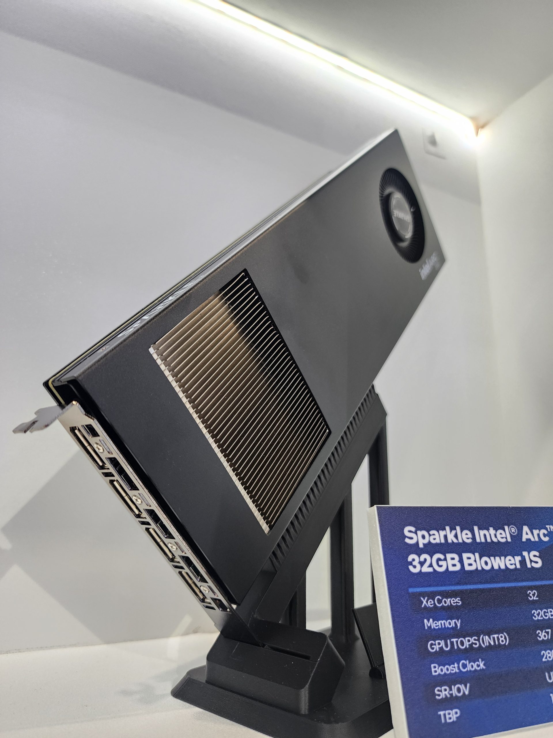 A Sparkle Intel Arc 32GB Blower 1S GPU is displayed on a stand with specifications including 'Xe Cores: 32,' 'Memory: 32GB,' and 'GPU TOPS (INT8): 367' visible on a card.