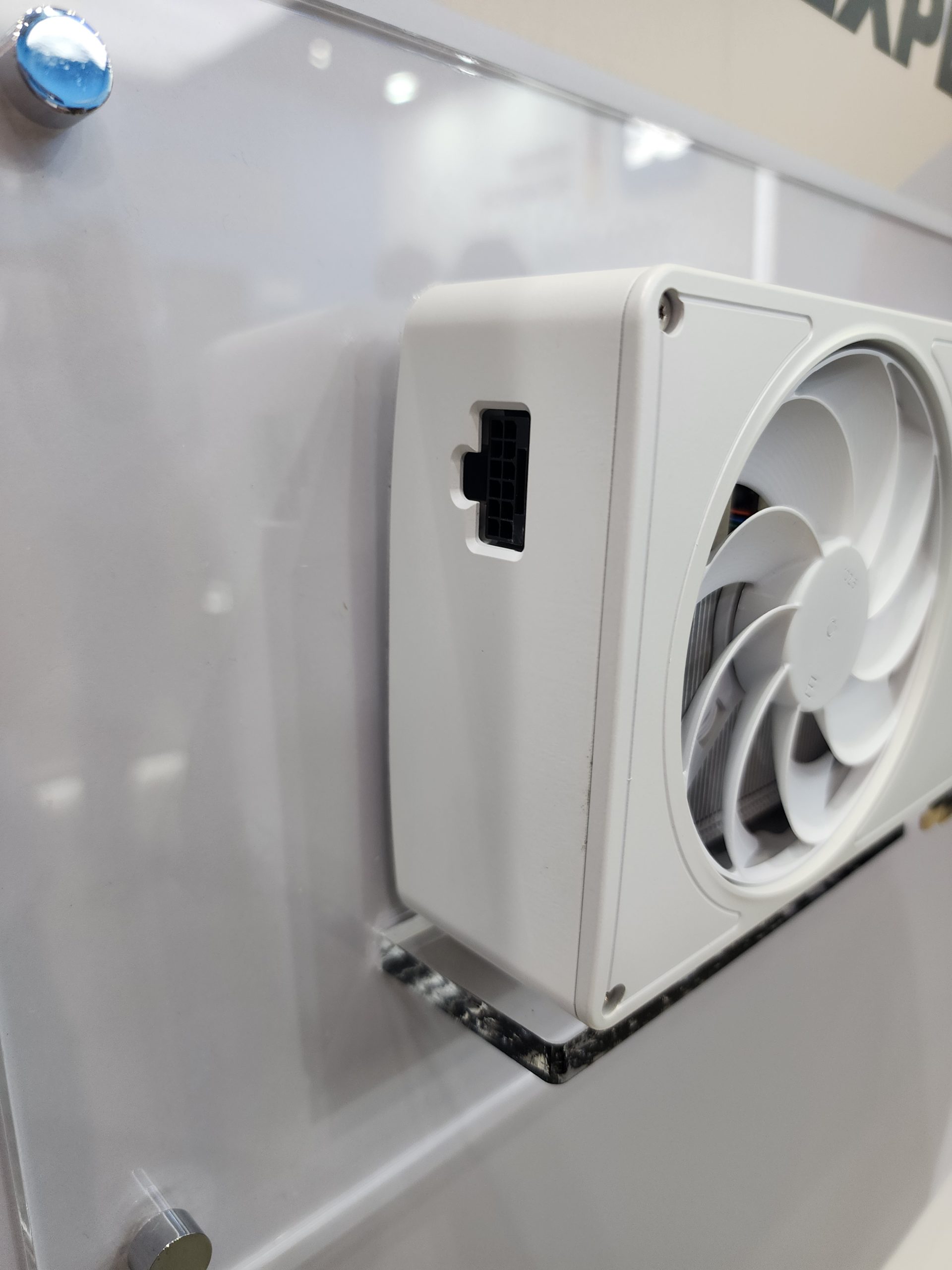A white 8-pin GPU power connector is visible on an unbranded graphics card mounted on a display board.