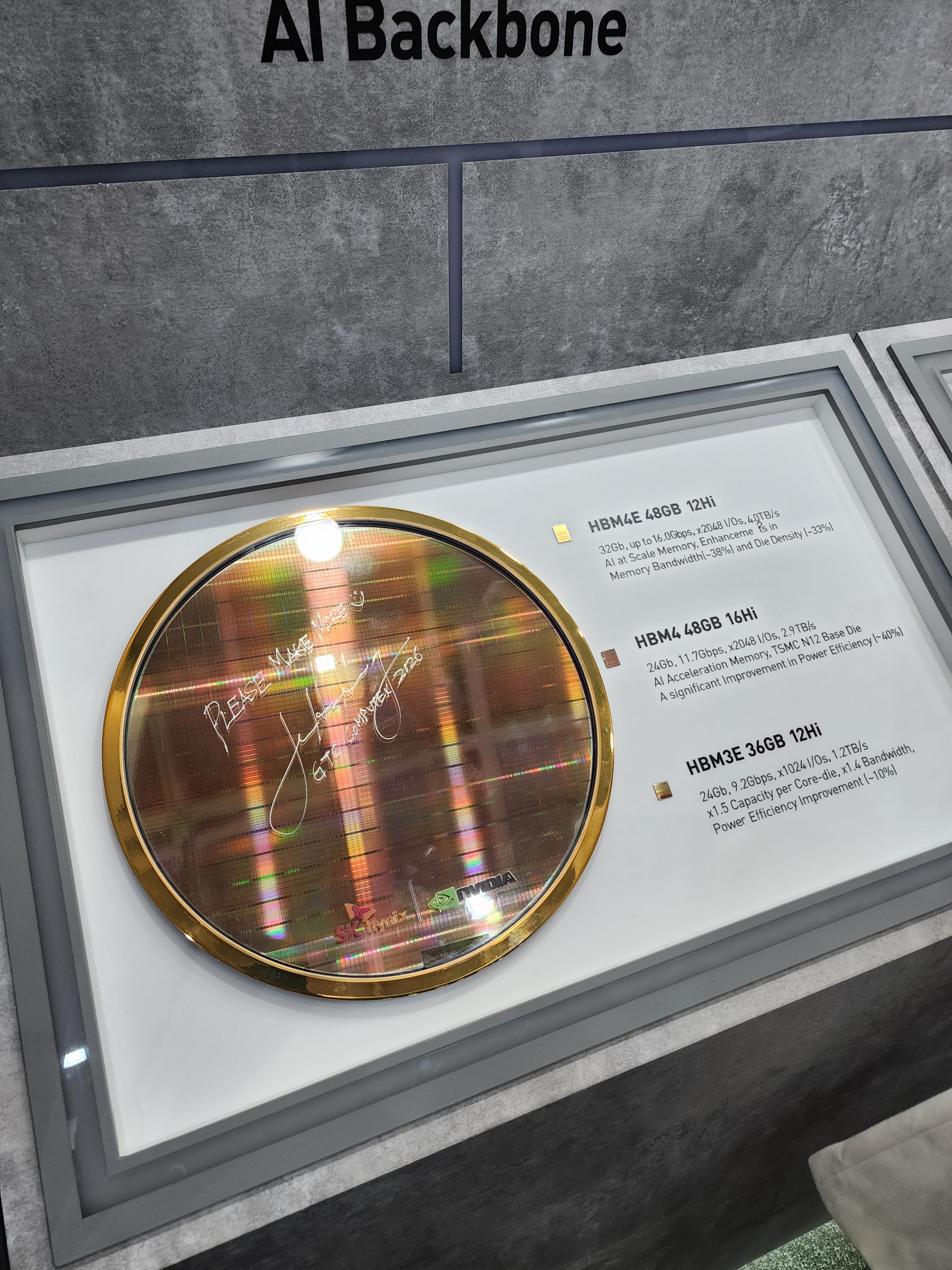 A gold-framed silicon wafer by SK hynix and NVIDIA is displayed, with inscription Please Make and signed by Jensen Huang at GT Computex 2023, alongside specifications for 'HBM4E 48GB 12Hi'.