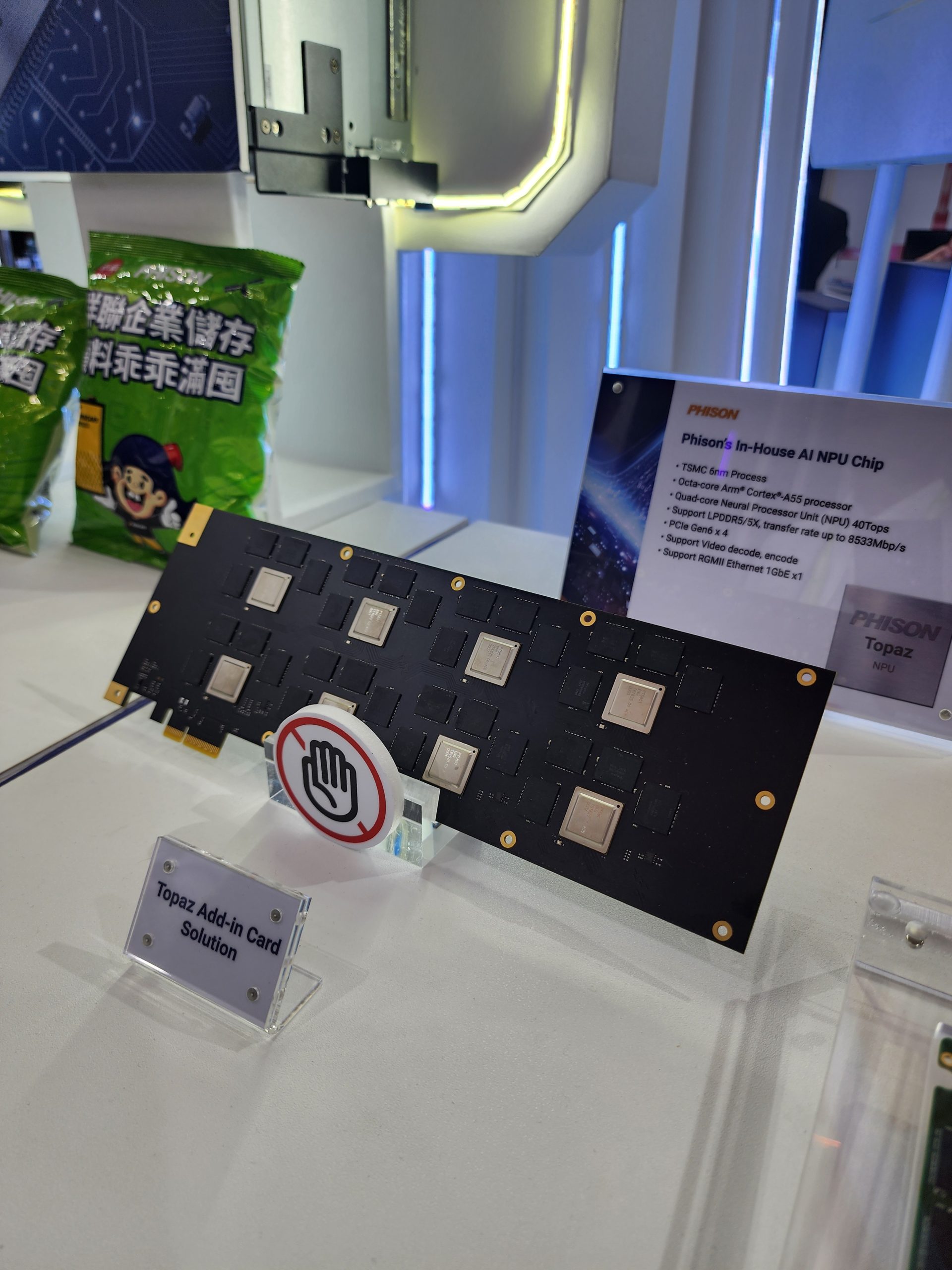 A Phison 'In-House AI NPU Chip' is displayed alongside a sign reading 'Topaz Add-in Card Solution,' showcasing specifications like 'TSMC 6nm Process' and 'Quad-core Neural Processor Unit (NPU) 40TOPs.'