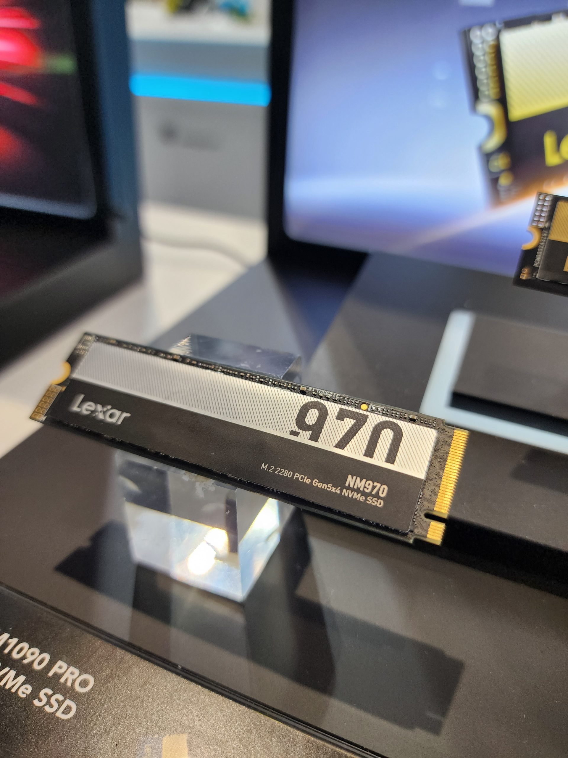 The image shows a Lexar NM970 M.2 2280 PCIe Gen5x4 NVMe SSD displayed on a stand.