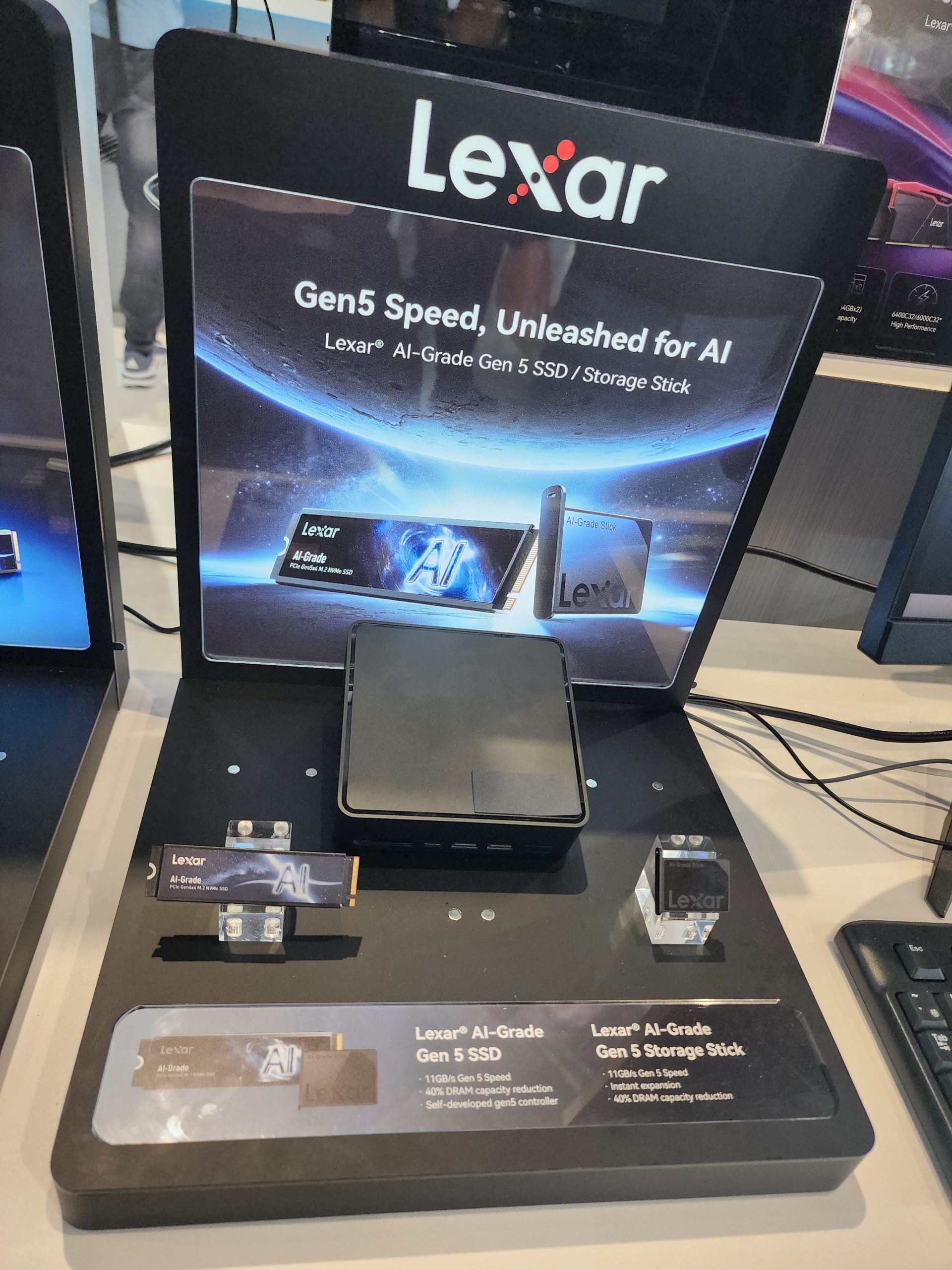 A display showcases Lexar AI-Grade Gen 5 SSD and Storage Stick with the text 'Gen5 Speed, Unleashed for AI.'