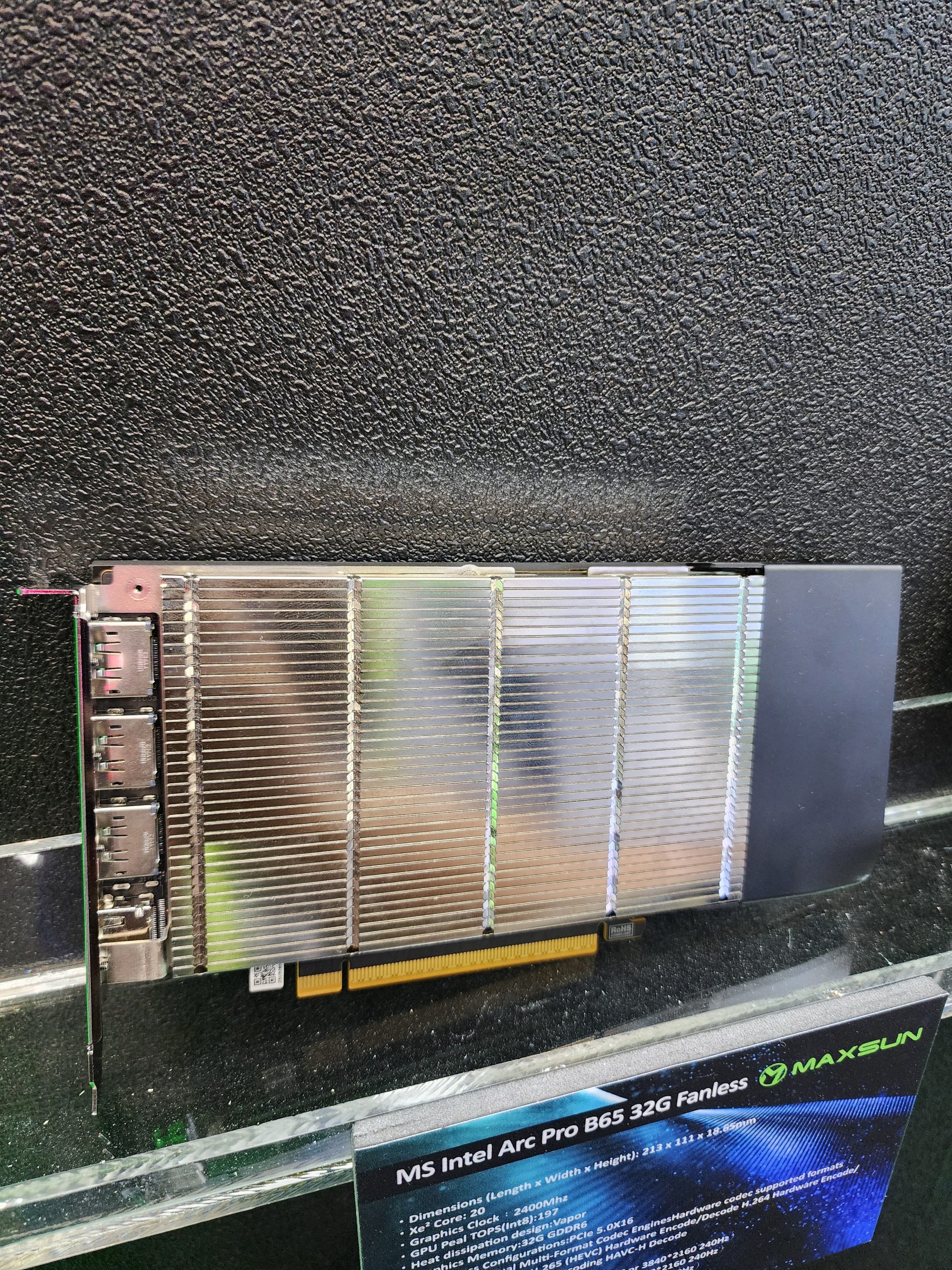 The image shows a Maxsun Intel Arc Pro B65 32G fanless graphics card with a large heatsink on display.