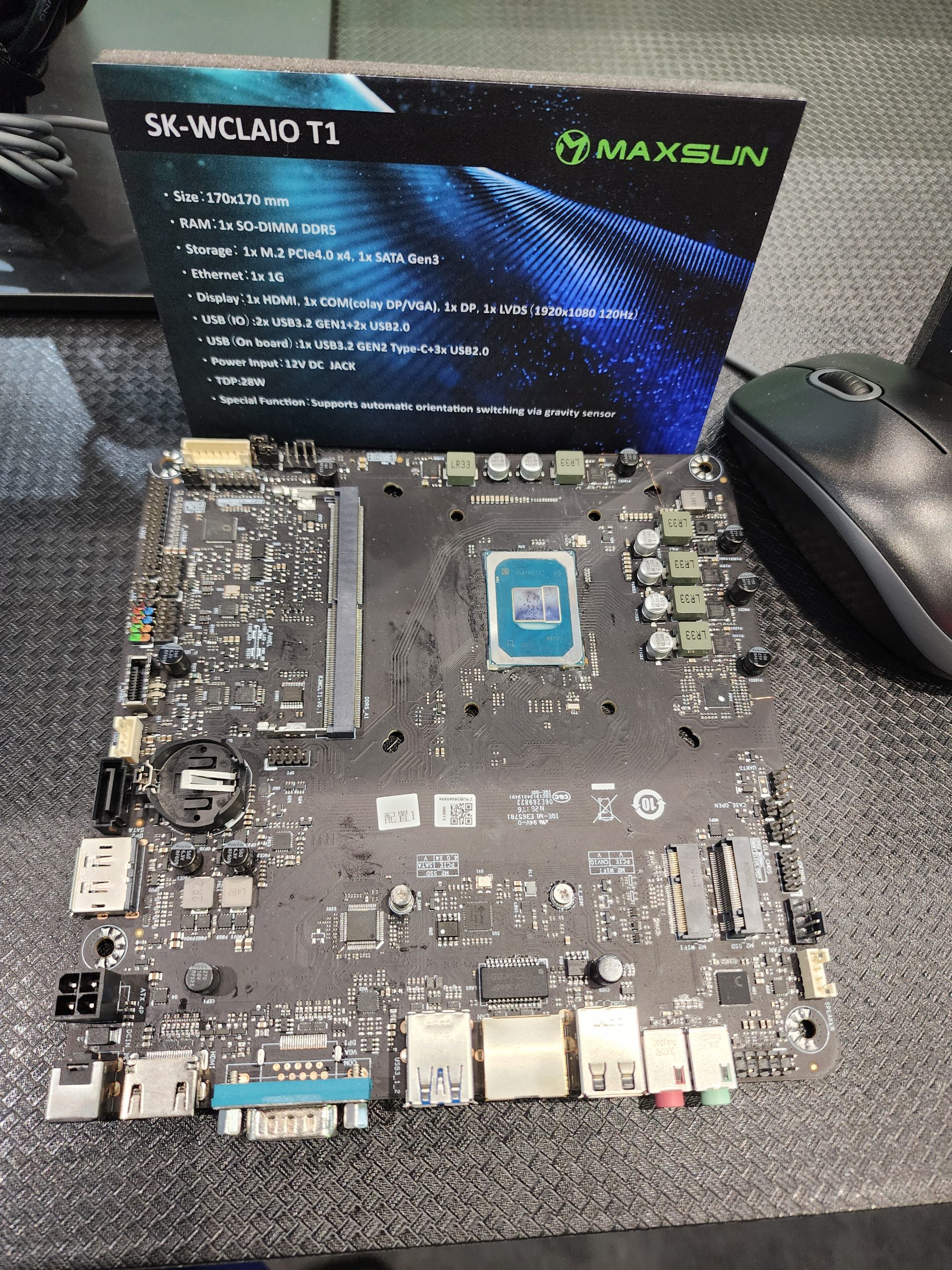 A Maxsun SK-WCLAIO T1 motherboard displayed with specifications including '1x SO-DIMM DDR5' and '1x M.2 PCIe4.0 x4, 1x SATA Gen3' in the background.